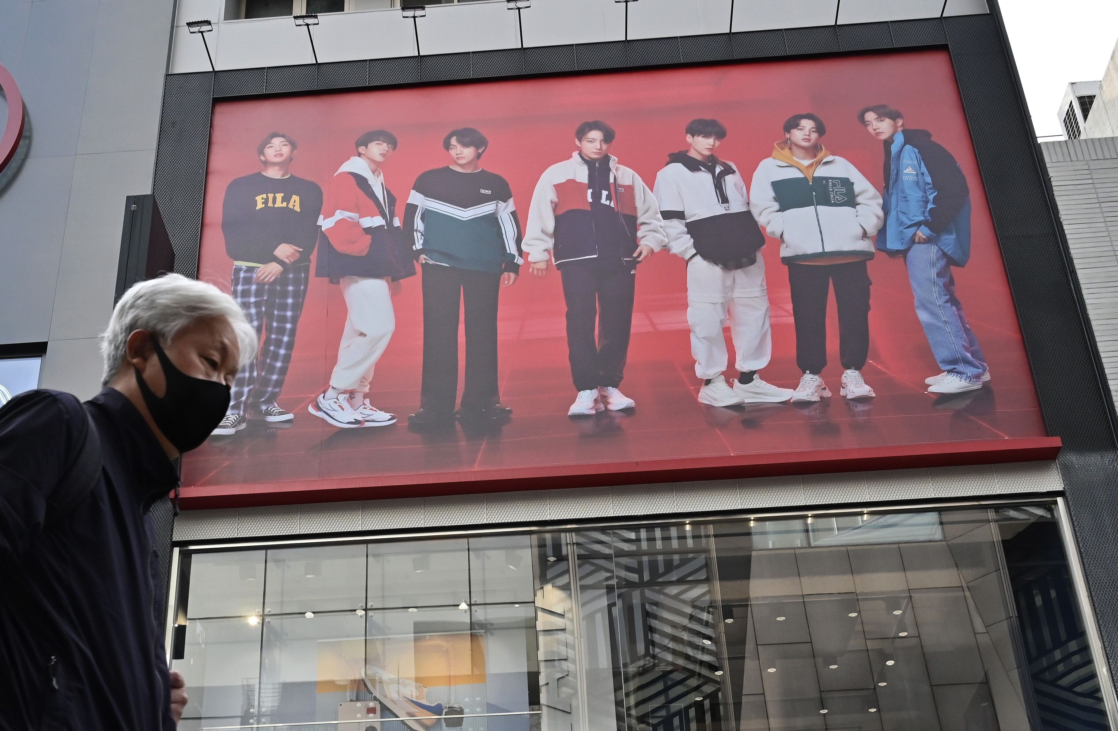 K-pop power is prevalent in China but the industry is at the mercy of China-South Korea relations. Here, a man walks past a poster showing K-pop group BTS members at a shopping district in Seoul on October 15, 2020, around the time Chinese netizens became enraged by singer RM’s comments about the Korean war. Photo: AFP