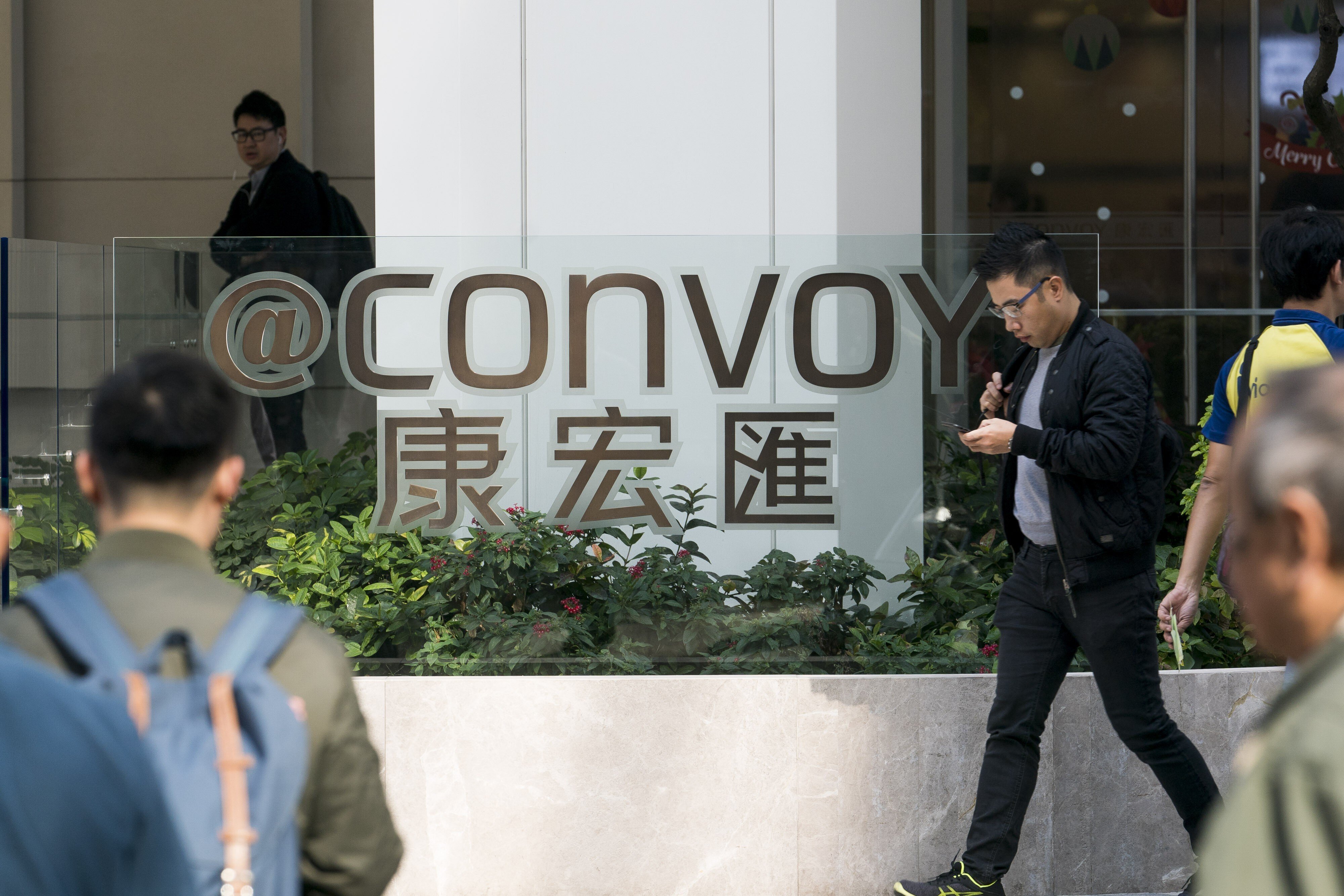 Pedestrians walk past the @Convoy building, which houses the headquarters of Convoy Global Holdings in Hong Kong in December 2017. Photo: Bloomberg