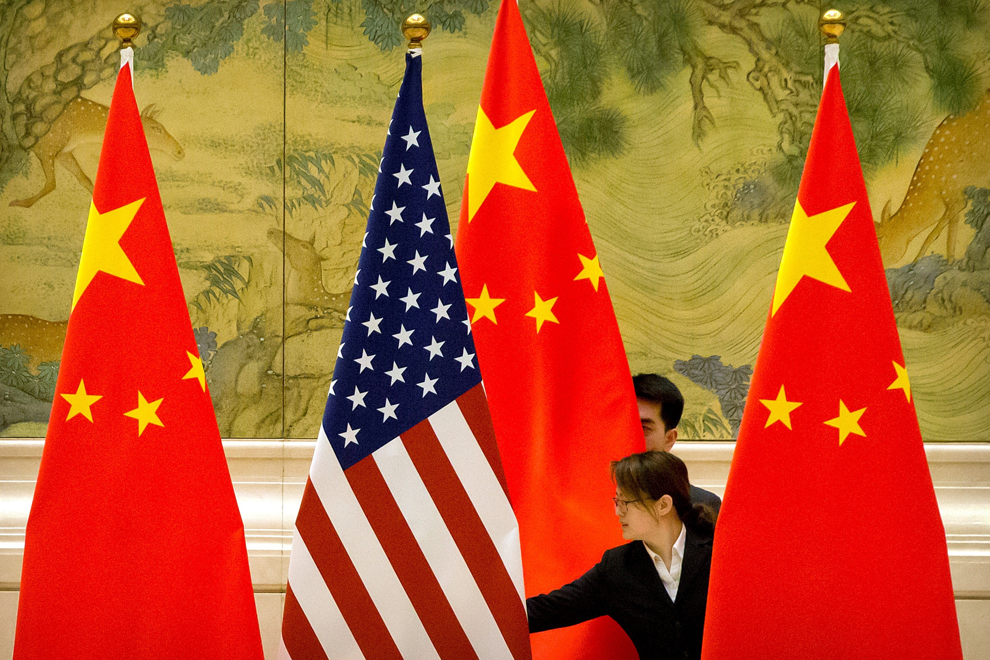 Chinese staff adjust US and Chinese flags before the opening session of trade negotiations between US and Chinese trade representatives at the Diaoyutai State Guesthouse in Beijing on February 14, 2019. Photo: Reuters