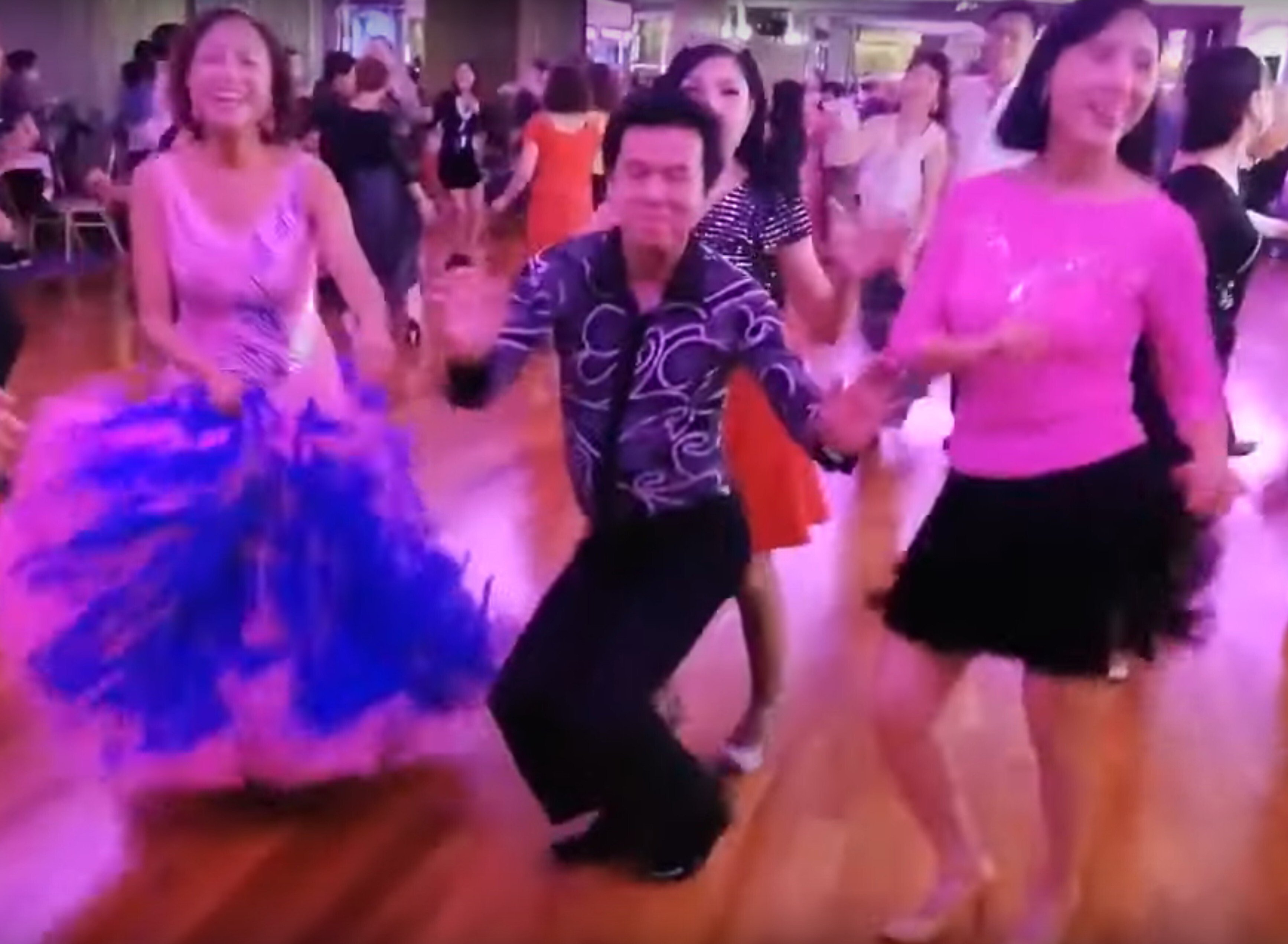 A screen grab of a video posted online shows a group of people dancing without face masks at Betterment Banquet Hall in Mei Foo. Source: Handout