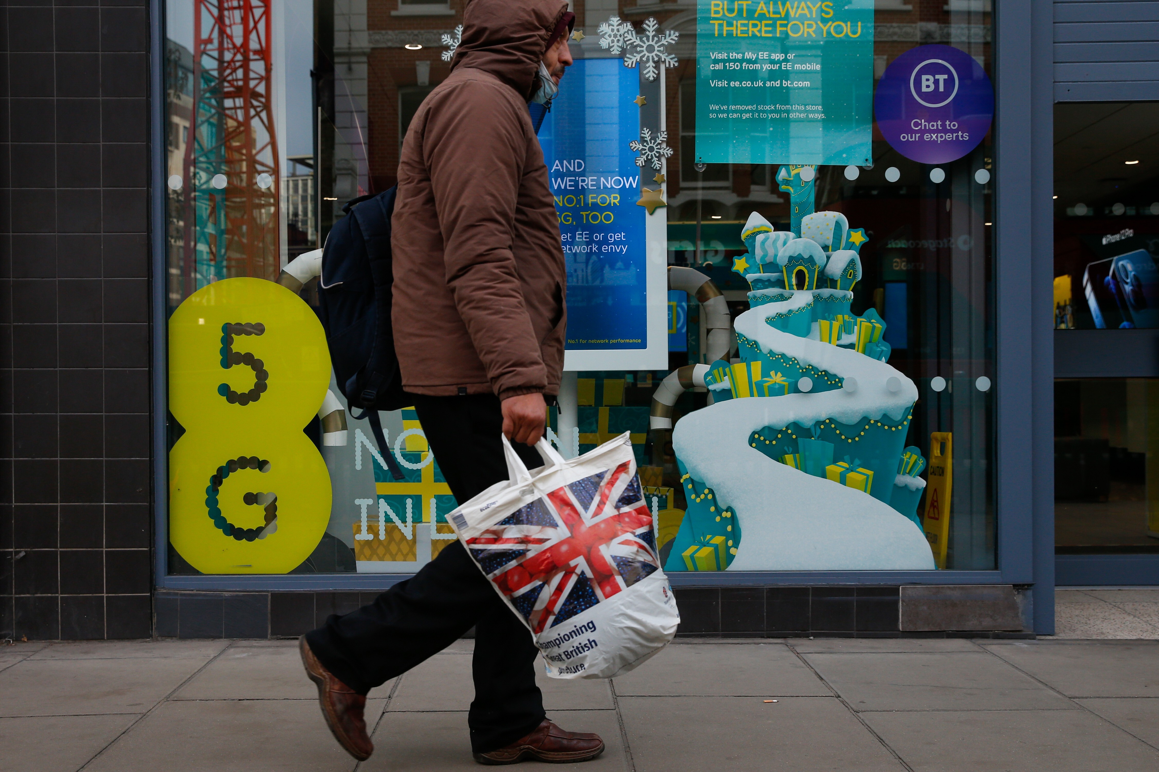 A pedestrian passes an EE store advertising 5G network capabilities in London, U.K., on Tuesday, Nov. 24, 2020. The U.K. is considering a ban on the installation of Huawei Technologies Co. 5G equipment as soon as next year to appease hawks pushing for tighter restrictions on the Chinese network equipment maker, according to people familiar with the matter. Photographer: Hollie Adams/Bloomberg