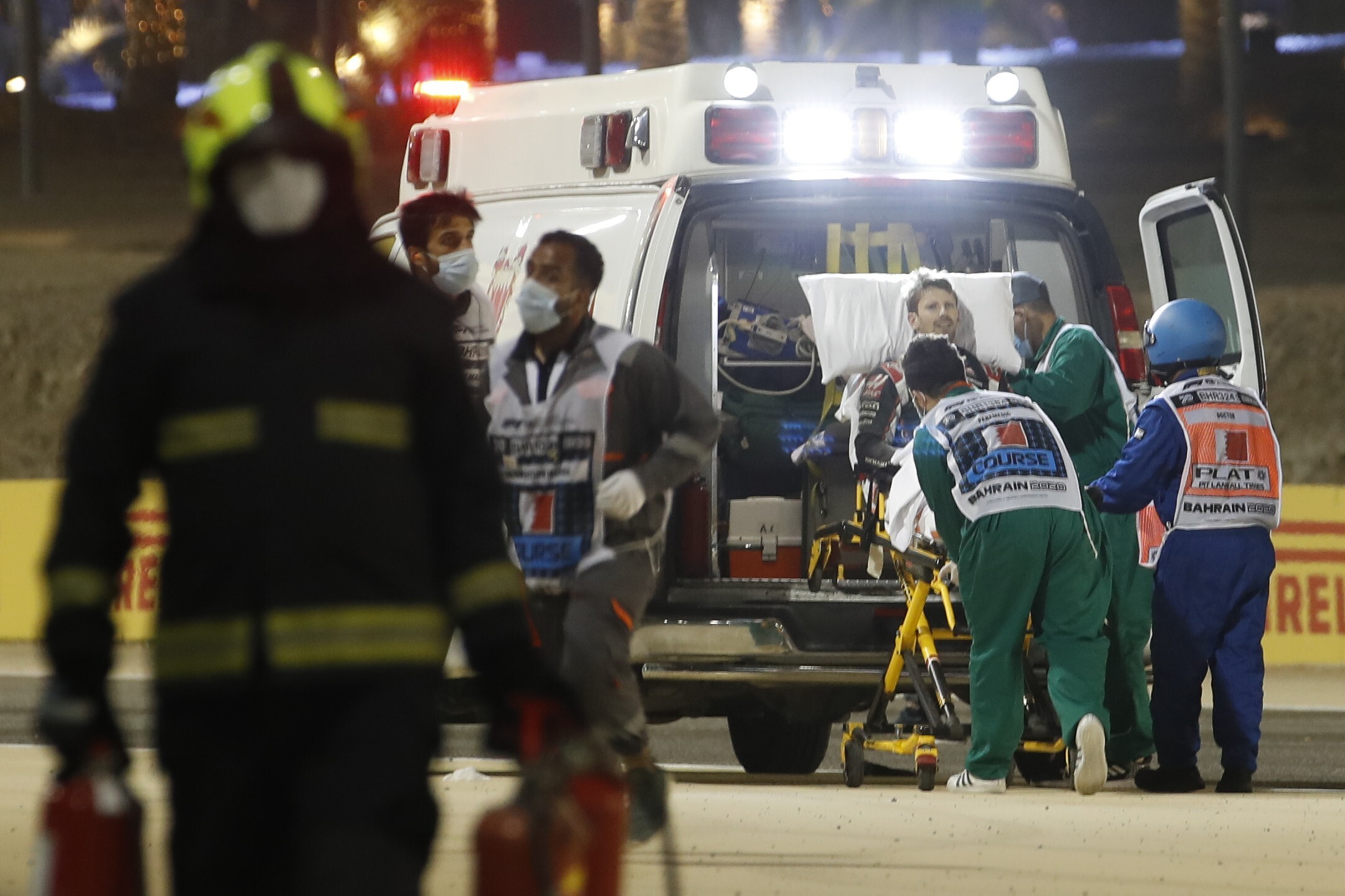 Romain Grosjean of France is helped by medical staff after he crashed his car during the F1 race in Bahrain on Sunday. Photo: AP