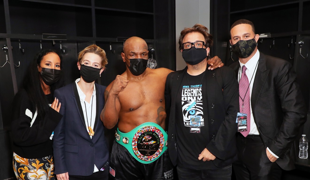 (From left to right) Kiki Tyson, Sophie Watts, Mike Tyson, John Ryan, and Azheem Spicer pose in the locker room after the Mike Tyson vs Roy Jones Jnr exhibition fight. Photo: EPA