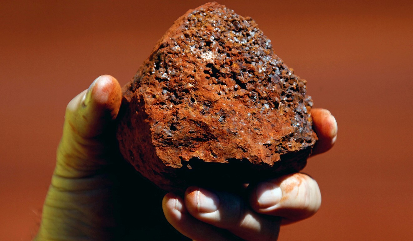 A miner holds a lump of iron ore at a mine located in the Pilbara region of Western Australia. Photo: Reuters