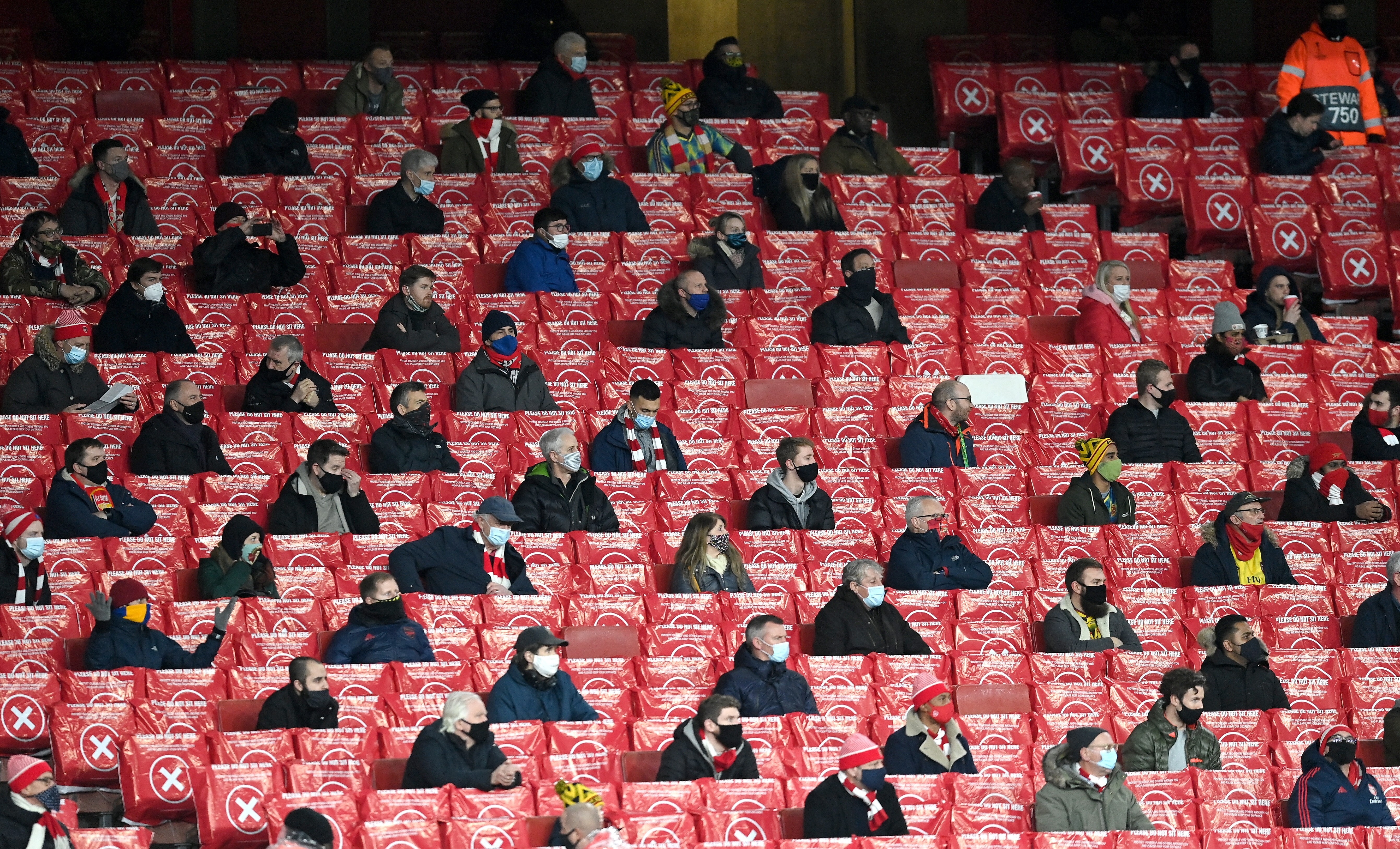 Arsenal fans are socially distanced between blocked seats at the Europa League group B match against Rapid Vienna in London. Photo: EPA