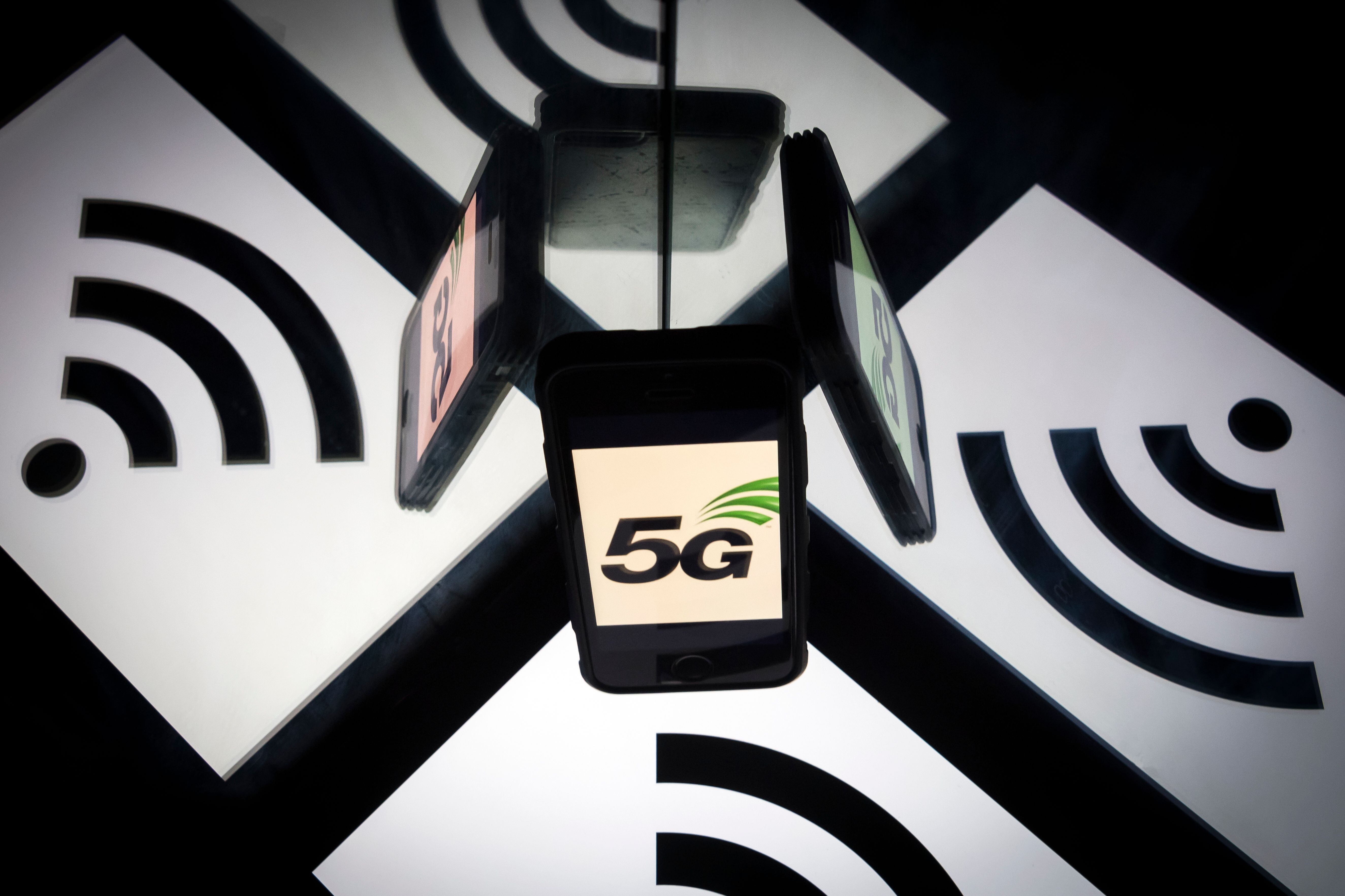 (FILES) In this file photo taken on February 17, 2019 This illustration picture shows the 5 G wireless technology logo displayed on a smartphone and a wireless signal sign displayed by a tablet in Paris. Photo: Agence France-Presse