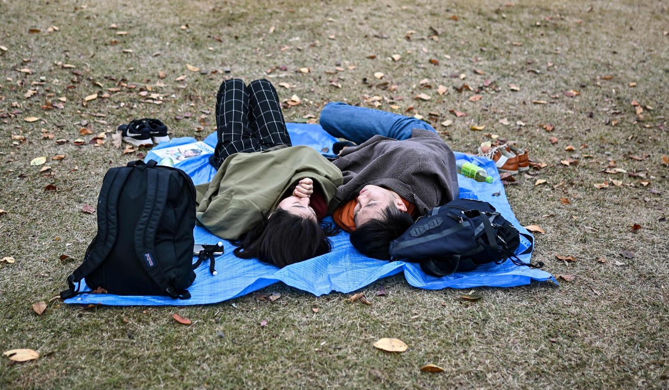 A couple lay on the grass in a park in Tokyo last month. Photo: AFP