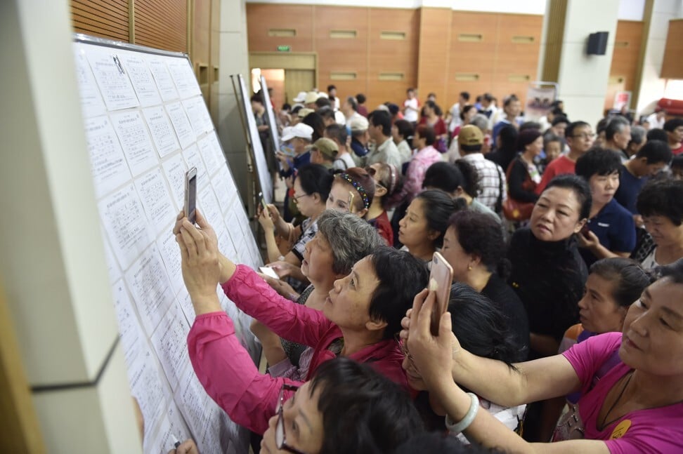 Elderly people view marriage-seeking leaflets during a blind date event in Harbin. More single elderly people are longing for love and companionship. Photo: Getty Images