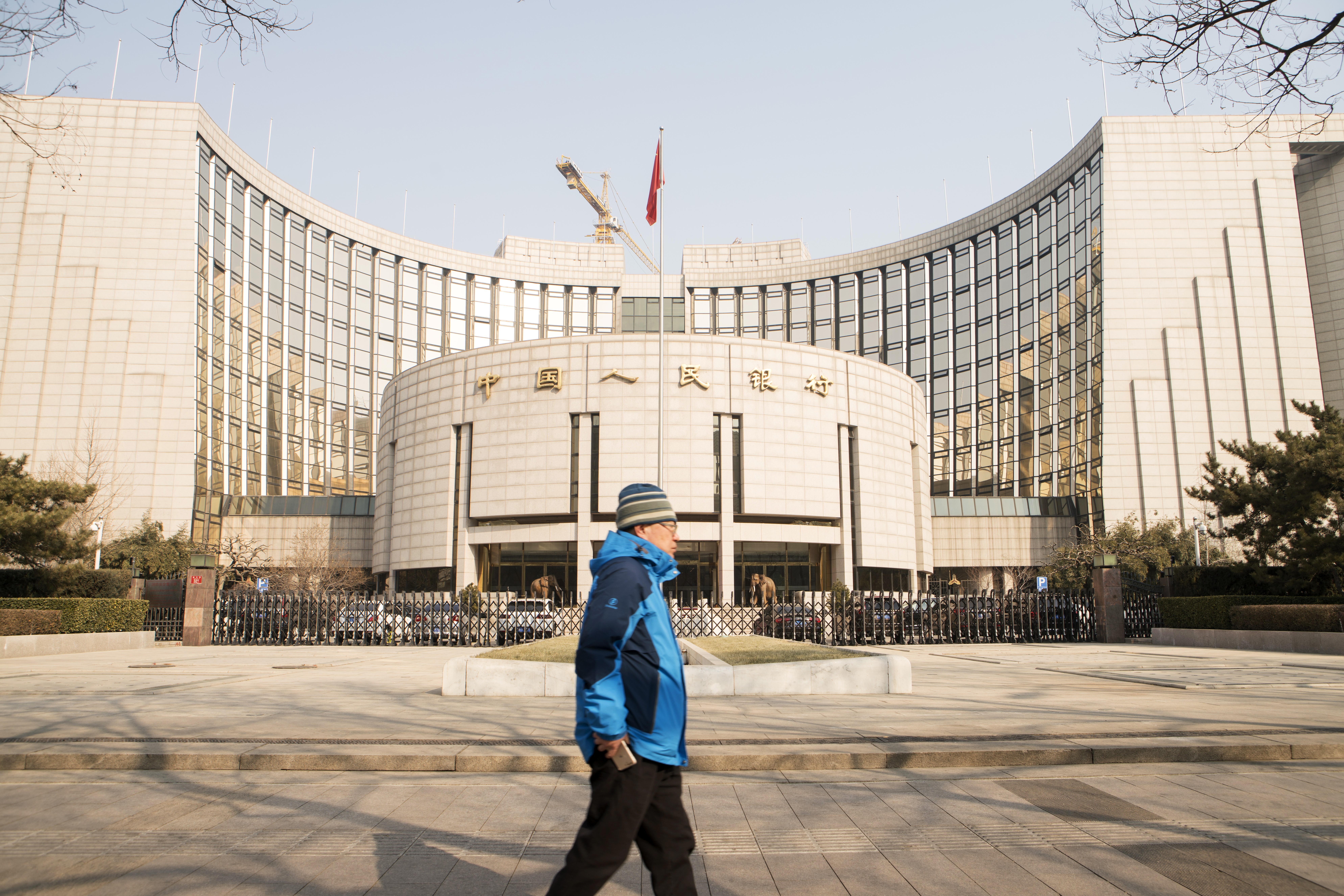 A pedestrian walks past the People's Bank of China headquarters in Beijing. Photo: Bloomberg