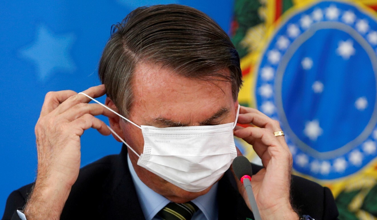 O presidente do Brasil, Jair Bolsonaro, ajusta sua máscara facial durante uma entrevista coletiva em março.  A pressão sobre Bolsonaro está aumentando à medida que outros países da região tentam aumentar seus suprimentos de vacinas.  Foto: Reuters
