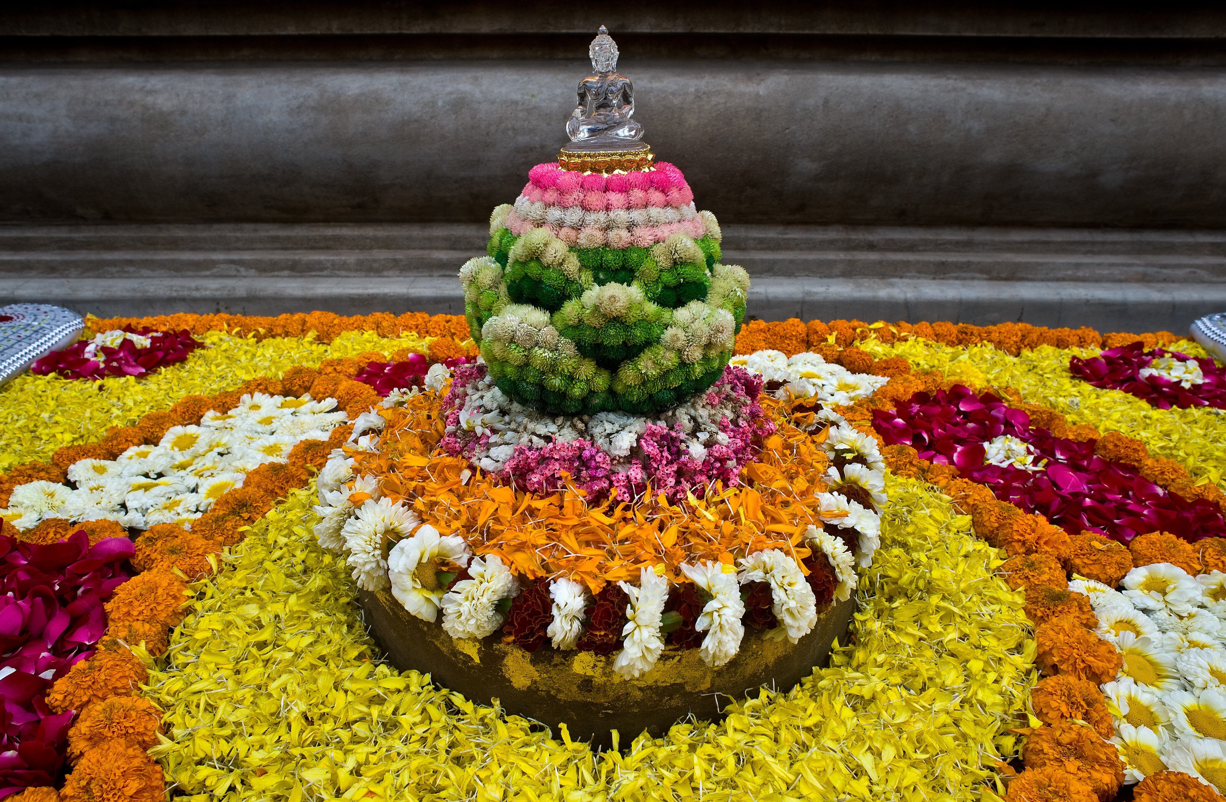 Flowers sit on and around a Buddhist statue at the Mahabodhi temple in Bodh Gaya, Bihar, India. Small companies are recycling some of the flowers left at India’s temples once they die. Photo: Getty Images