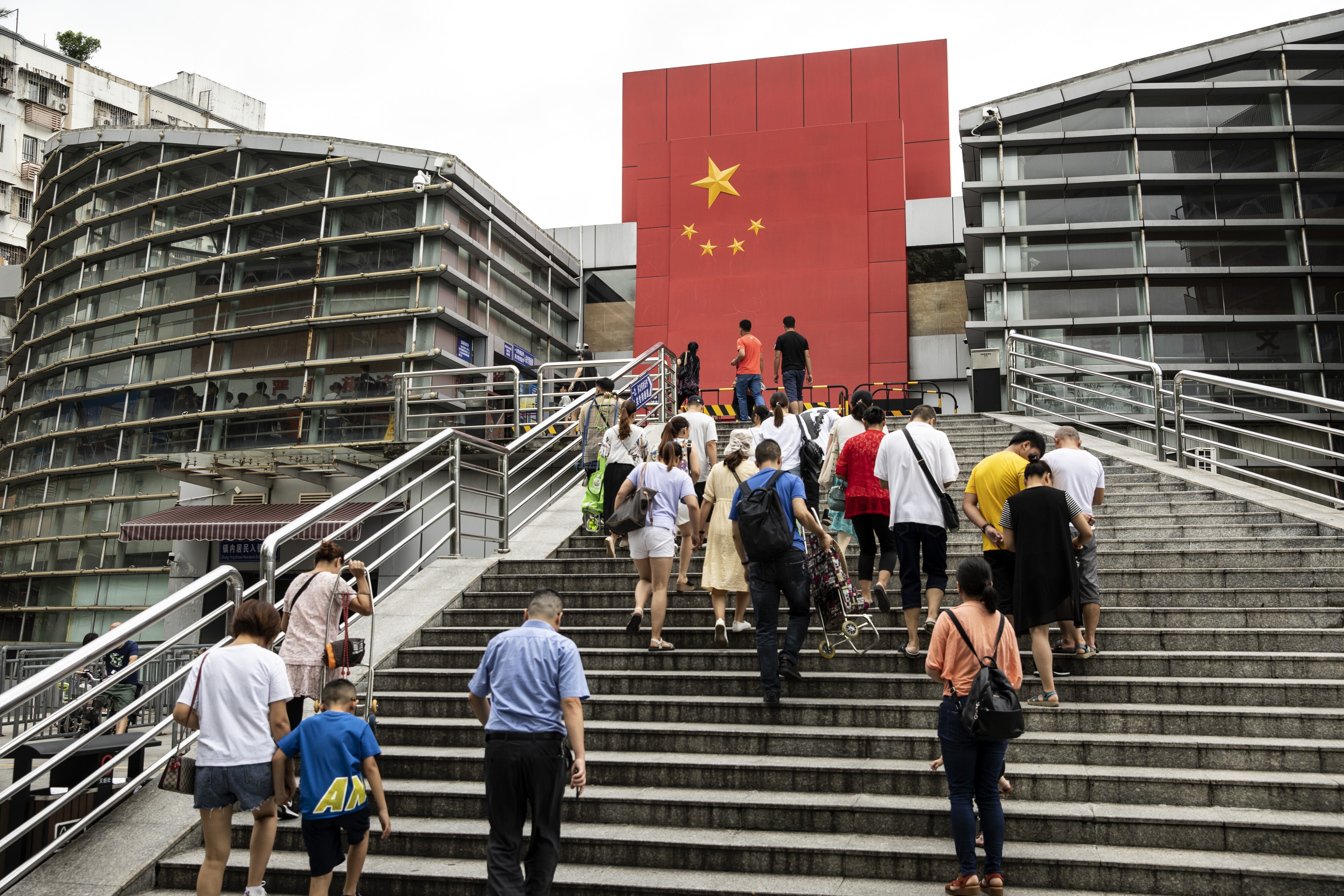 People walk up the steps at a border-crossing facility leading into Shenzhen. Photo: Bloomberg