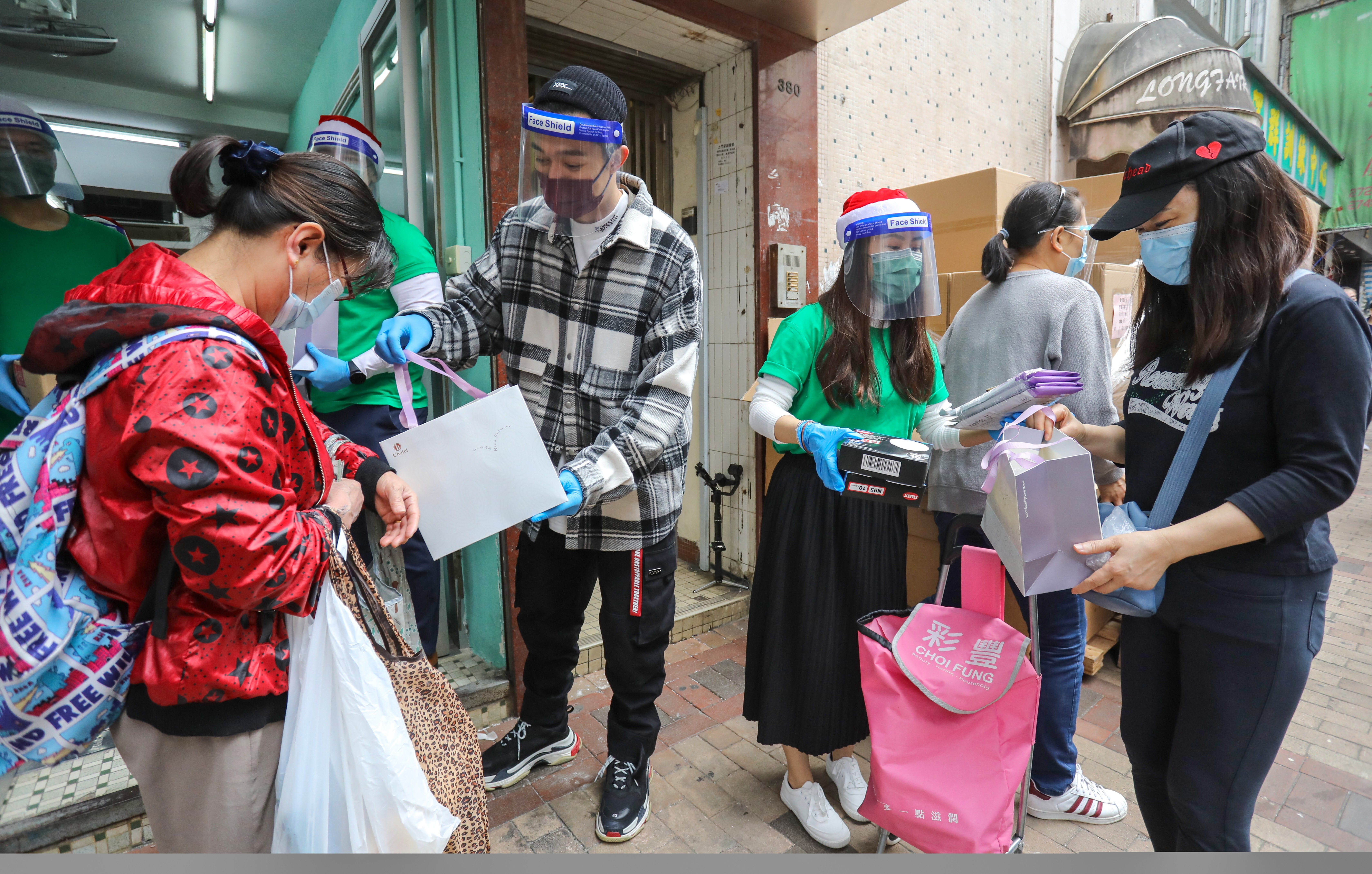 Operation Santa Claus ambassador Pakho Chau helps hand out supplies to Sham Shui Po residents last week. Photo: May Tse