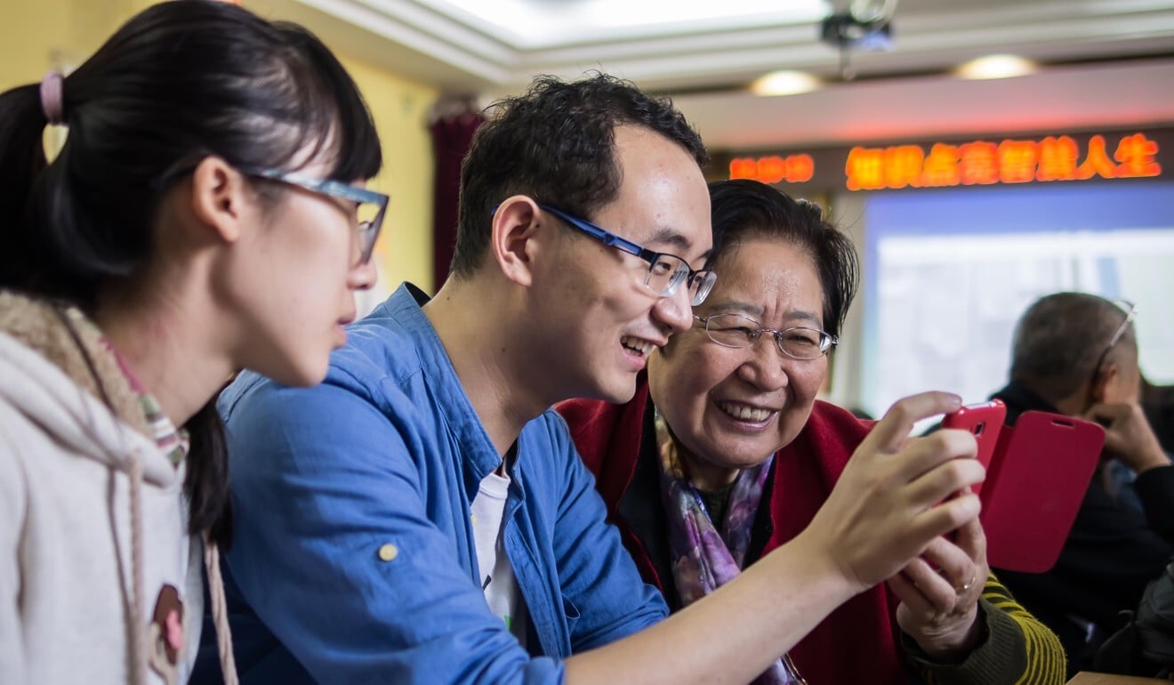 A representative of Beijing-based NGO See Young (centre) shows an elderly client how to use digital devices and mobile phone apps. Photo: courtesy of See Young A representative of Beijing-based NGO See Young (centre) shows an elderly client how to use digital devices and mobile phone apps. Photo: courtesy of See Young