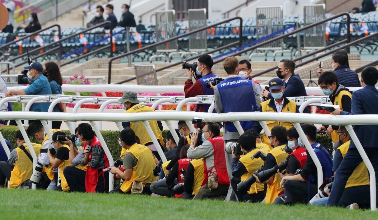 Photographers position themselves on the outside rail.