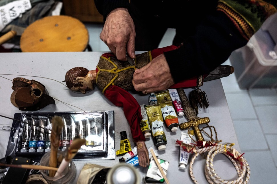 The puppets suffer wear and tear, and Grilli fixes them in his workshop. Photo: Marco Bertorello/AFP