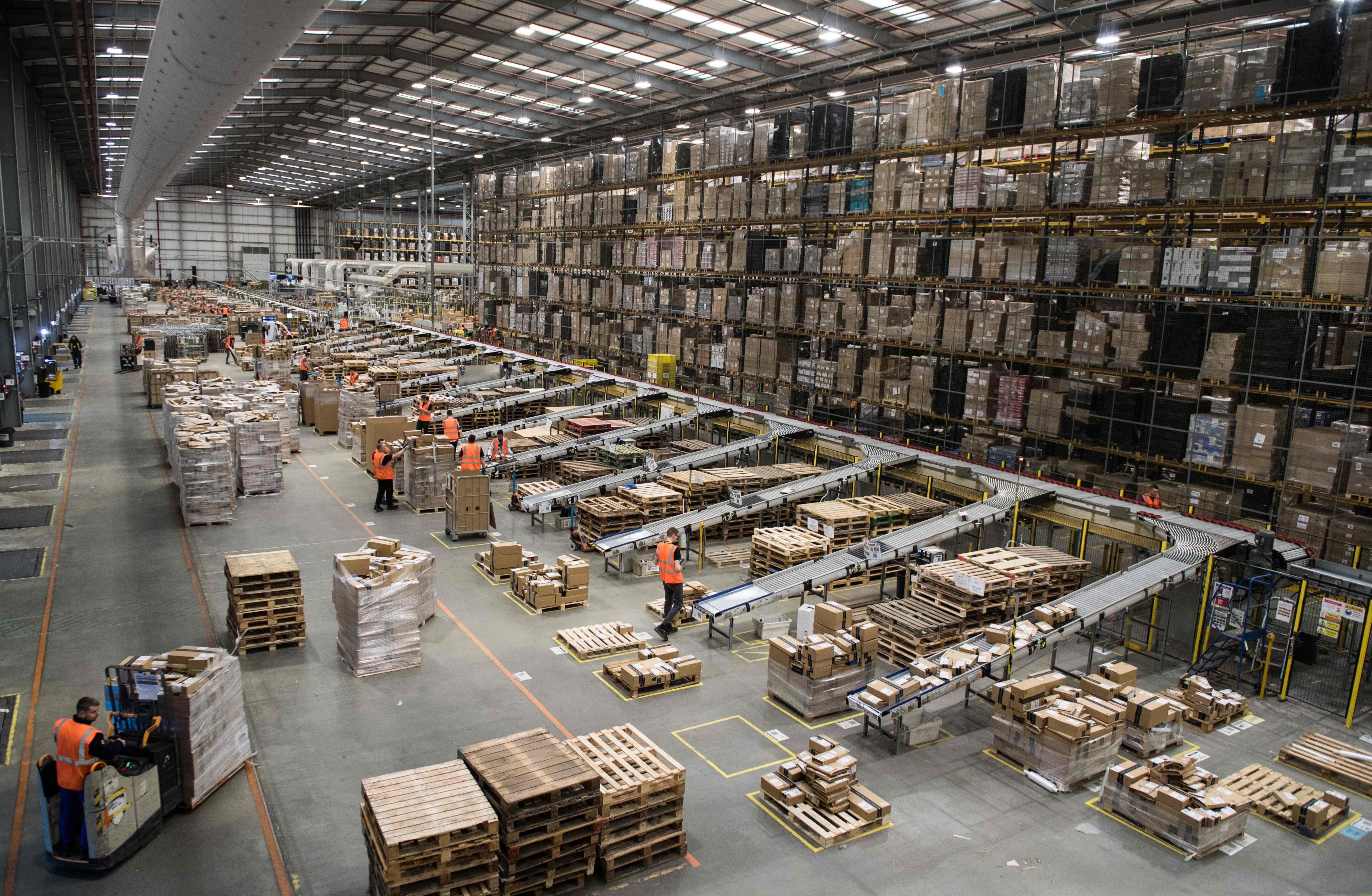 Workers prepare customer orders for dispatch as they work around goods stored inside an Amazon fulfilment centre in Peterborough, central England, on November 15, 2017. Photo: AFP