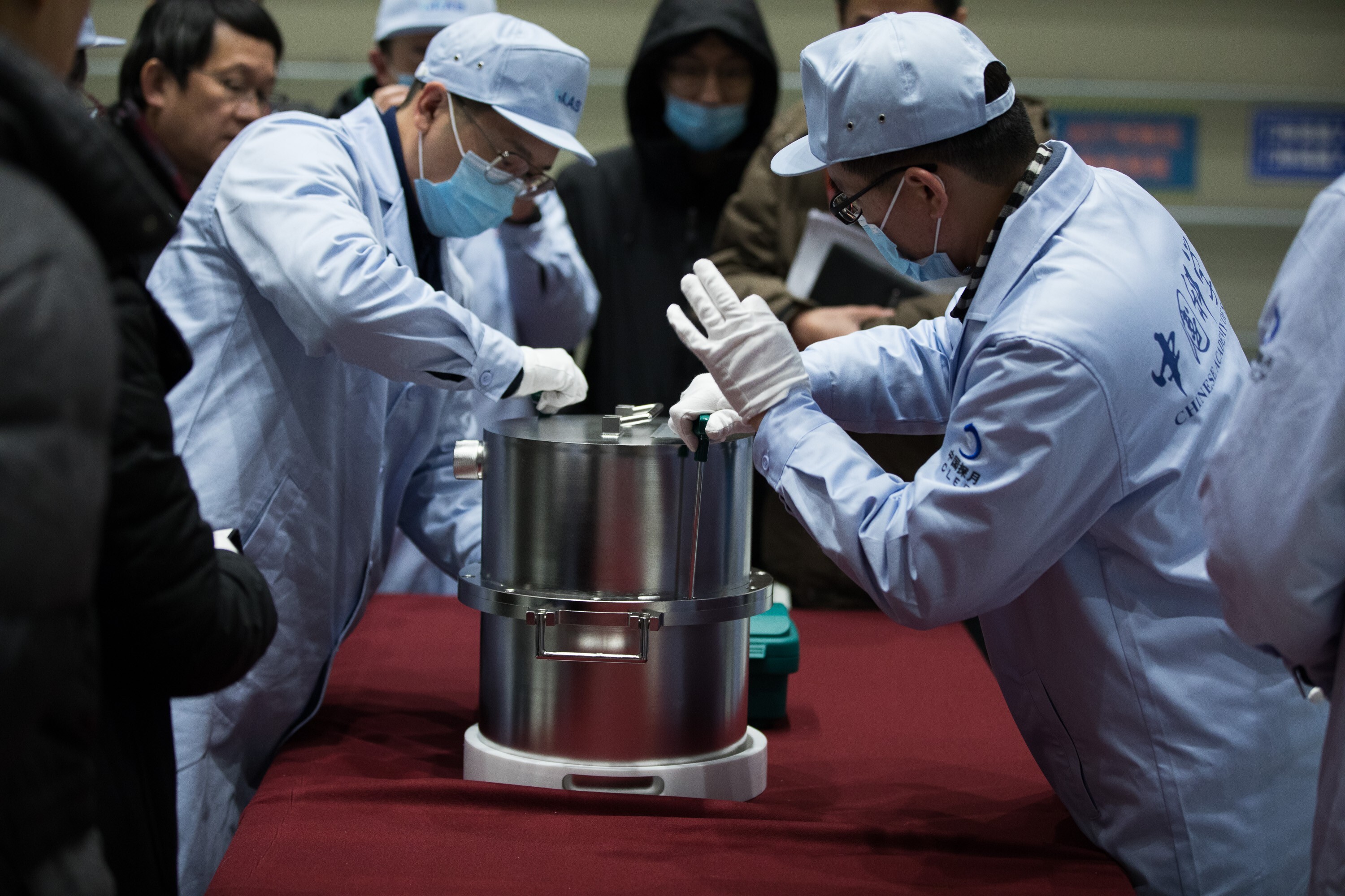 Scientific researchers transfer a container loaded with moon samples retrieved by the Chang’e-5 probe. Photo: Xinhua