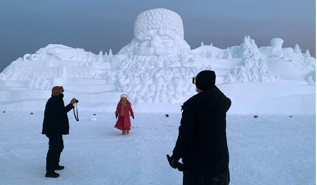 Visitors admire a giant snow sculpture of Santa Claus at the Christmas theme park on the outskirts of Mohe. Photo: Reuters