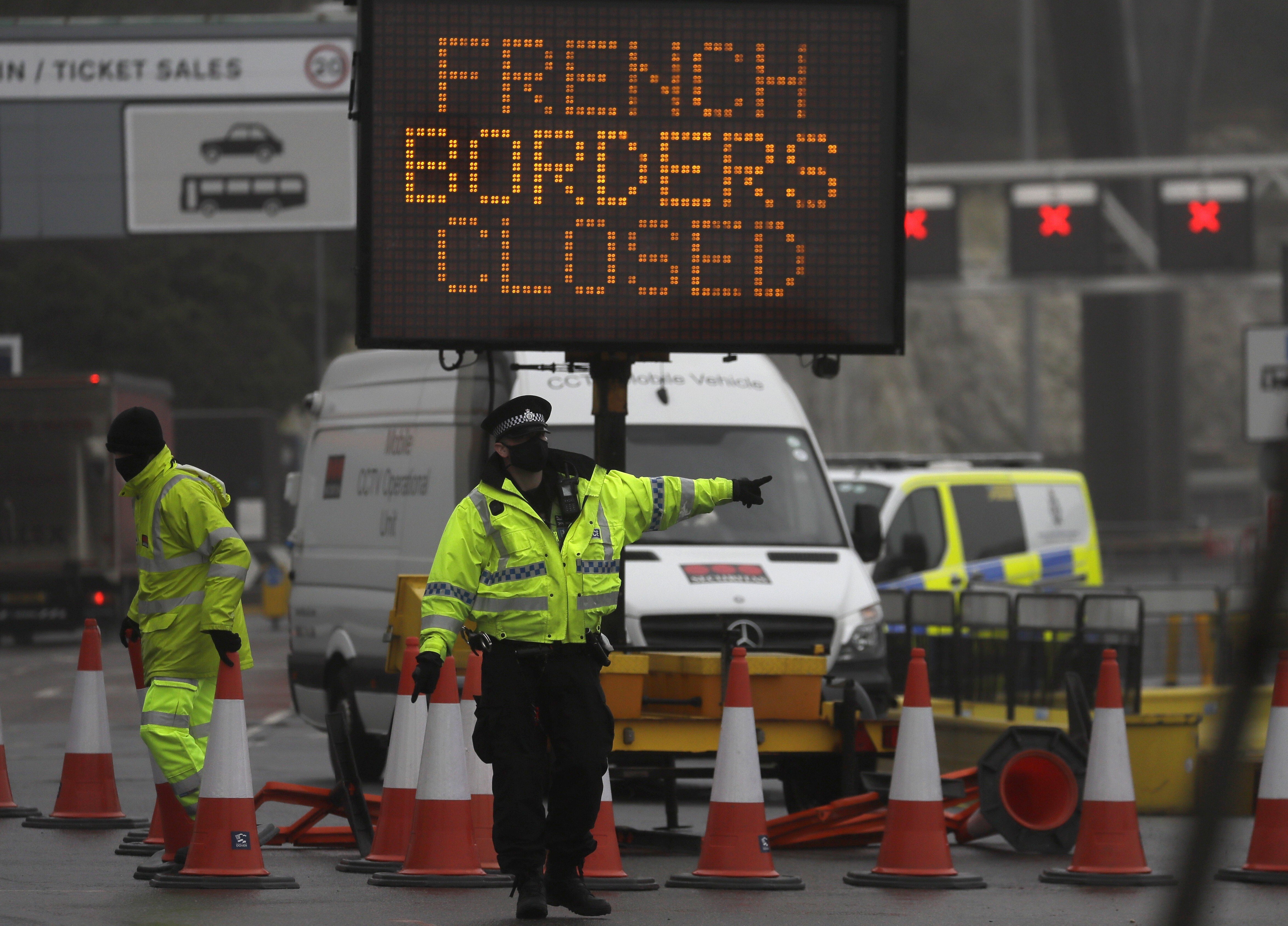 A police officer directs traffic at the closed ferry terminal in Dover, England. More than 30 countries and regions have now suspended travel with Britain because of a new strain of the coronavirus. Photo: AP