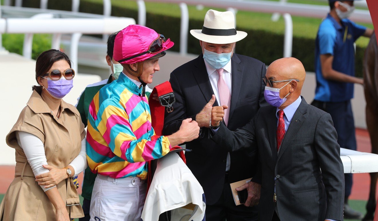 Jockey Chad Schofield and trainer David Hayes with connections of Super Axiom.