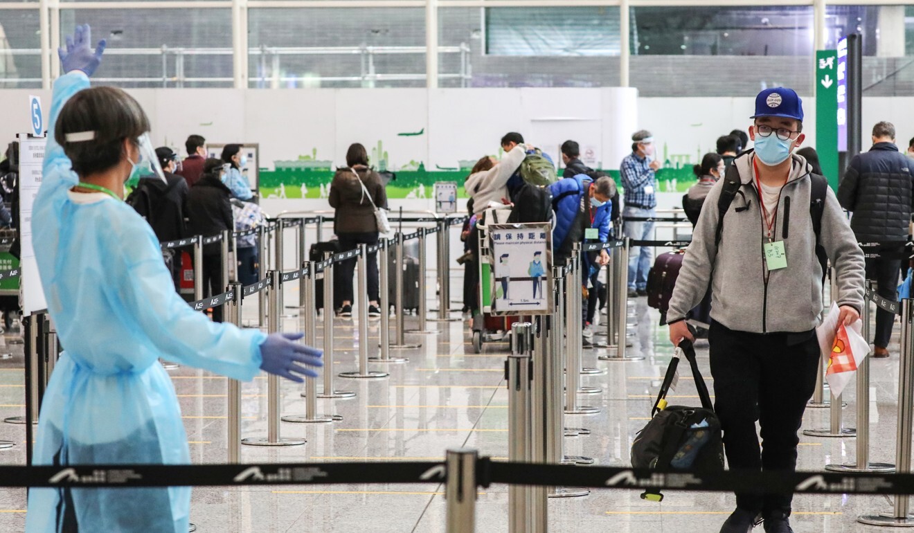 Arrivals at the airport are guided towards dedicated transport to carry them to designated quarantine hotels. Photo: Nora Tam