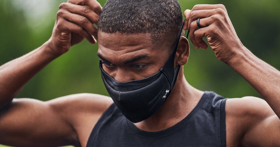 An athlete puts on an Under Armour sports mask before a training session.
