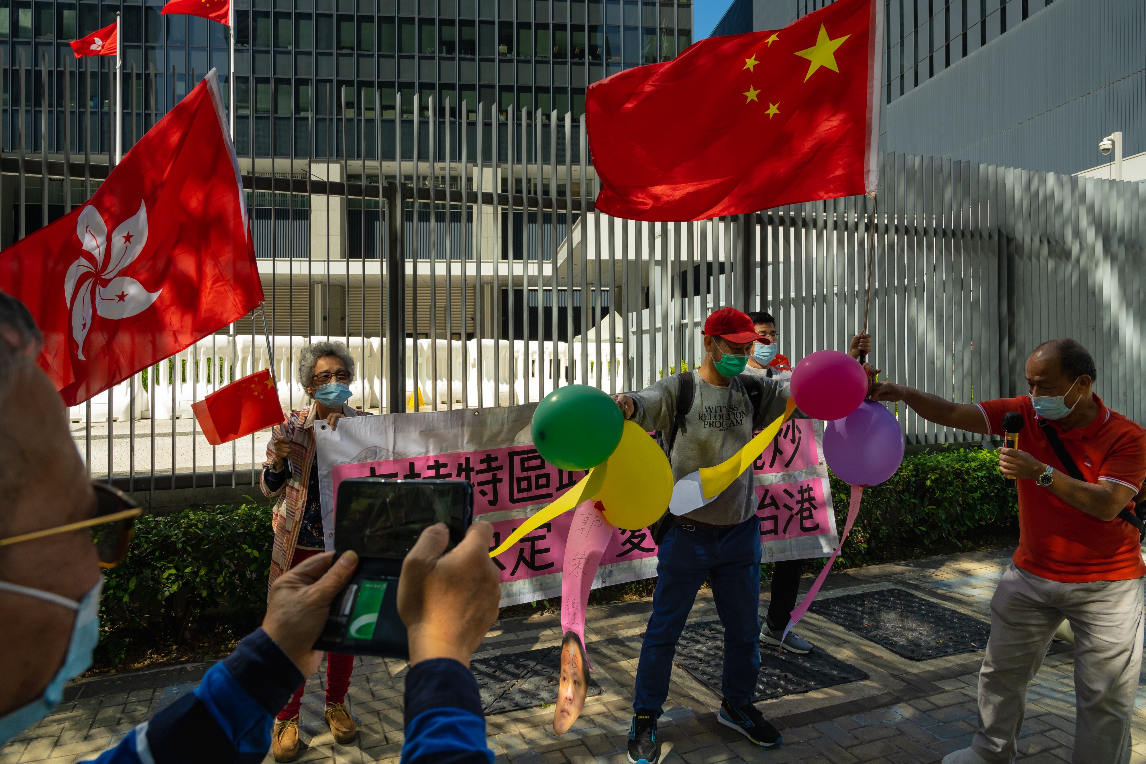 Pro-Beijing supporters wave the flags of Hong Kong and China outside the Legislative Council on November 12, after China passed a resolution allowing the disqualification of Hong Kong lawmakers deemed insufficiently patriotic. Photo: Bloomberg