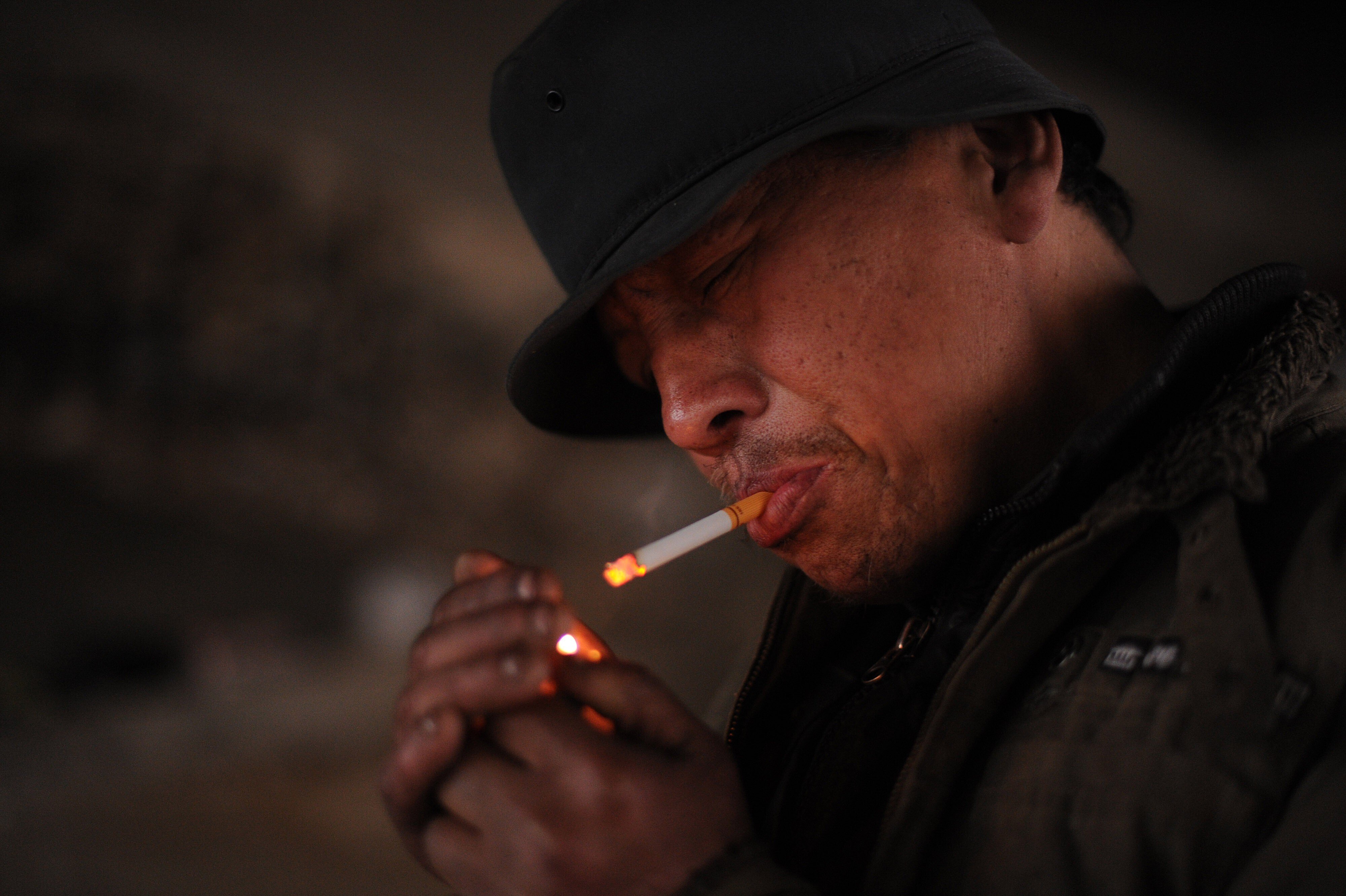 A homeless man lights up a cigarette in Hefei, Anhui province. In the study, those in poor areas had a 34.2 per cent smoking rate compared to the national average of 26.6 per cent. Photo: AFP