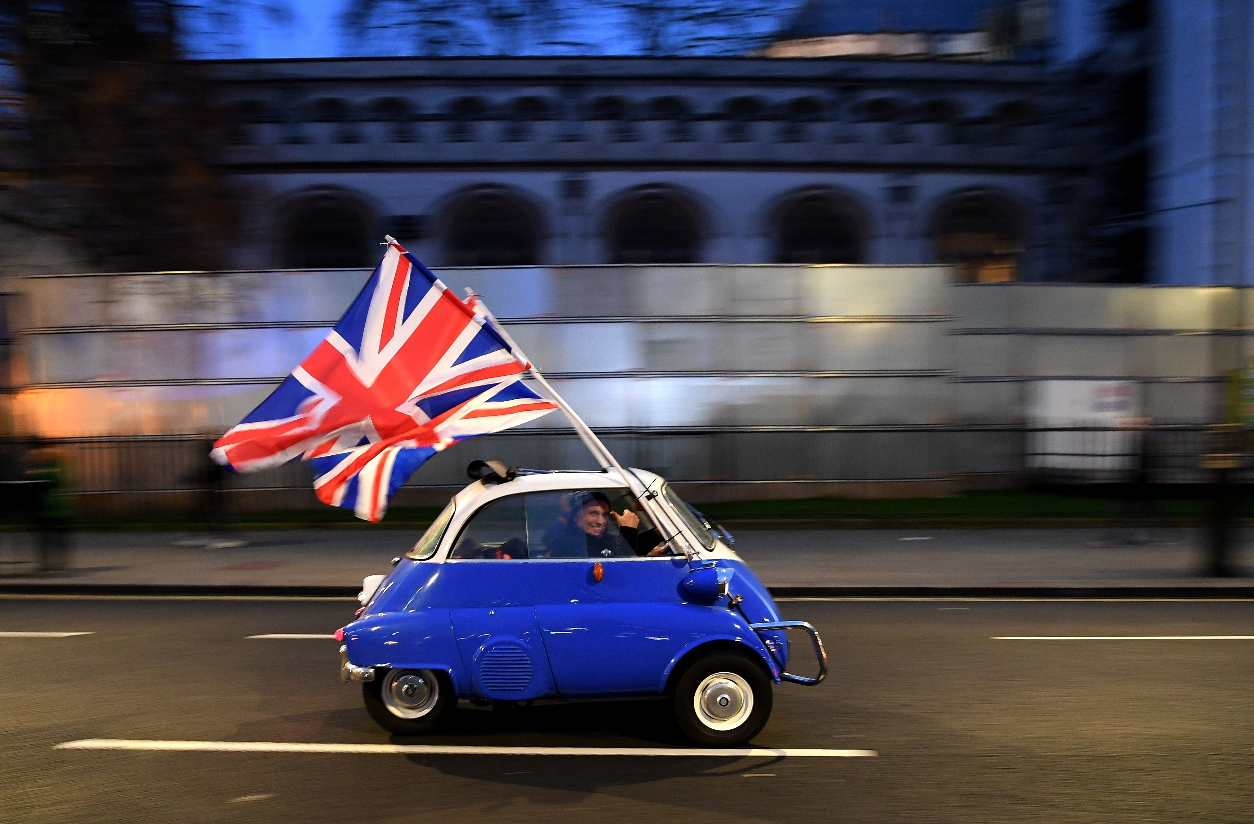 A man waves Union flags as he drives past Brexit supporters in Parliament Square in London on January 31. Photo: AFP