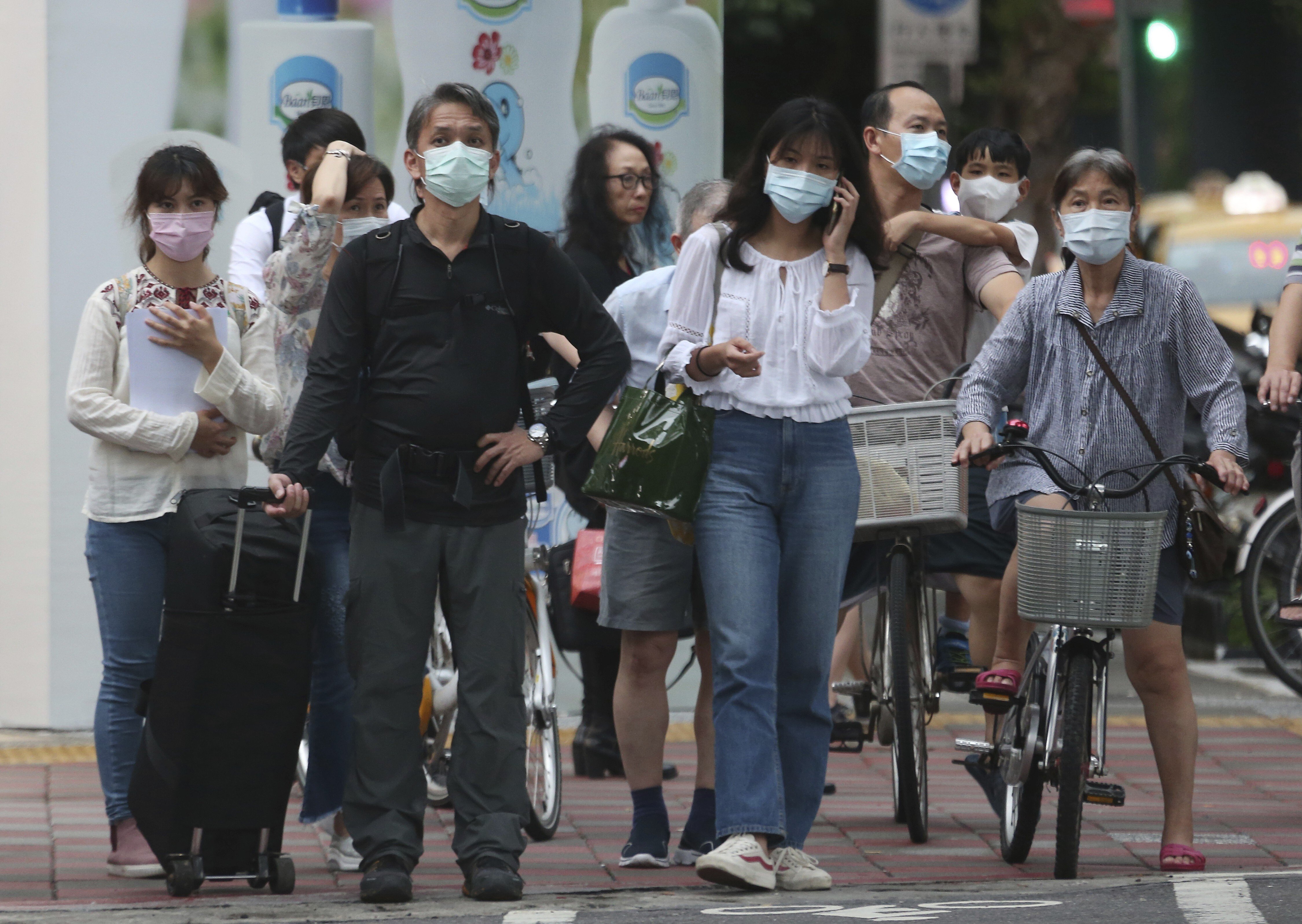 People wearing face masks to protect against the spread of the coronavirus travel around Taipei on May 18. Well-established practices such as wearing masks, transparency and trust in science have helped Taiwan assemble one of the world’s must successful Covid-19 pandemic responses. Photo: AP