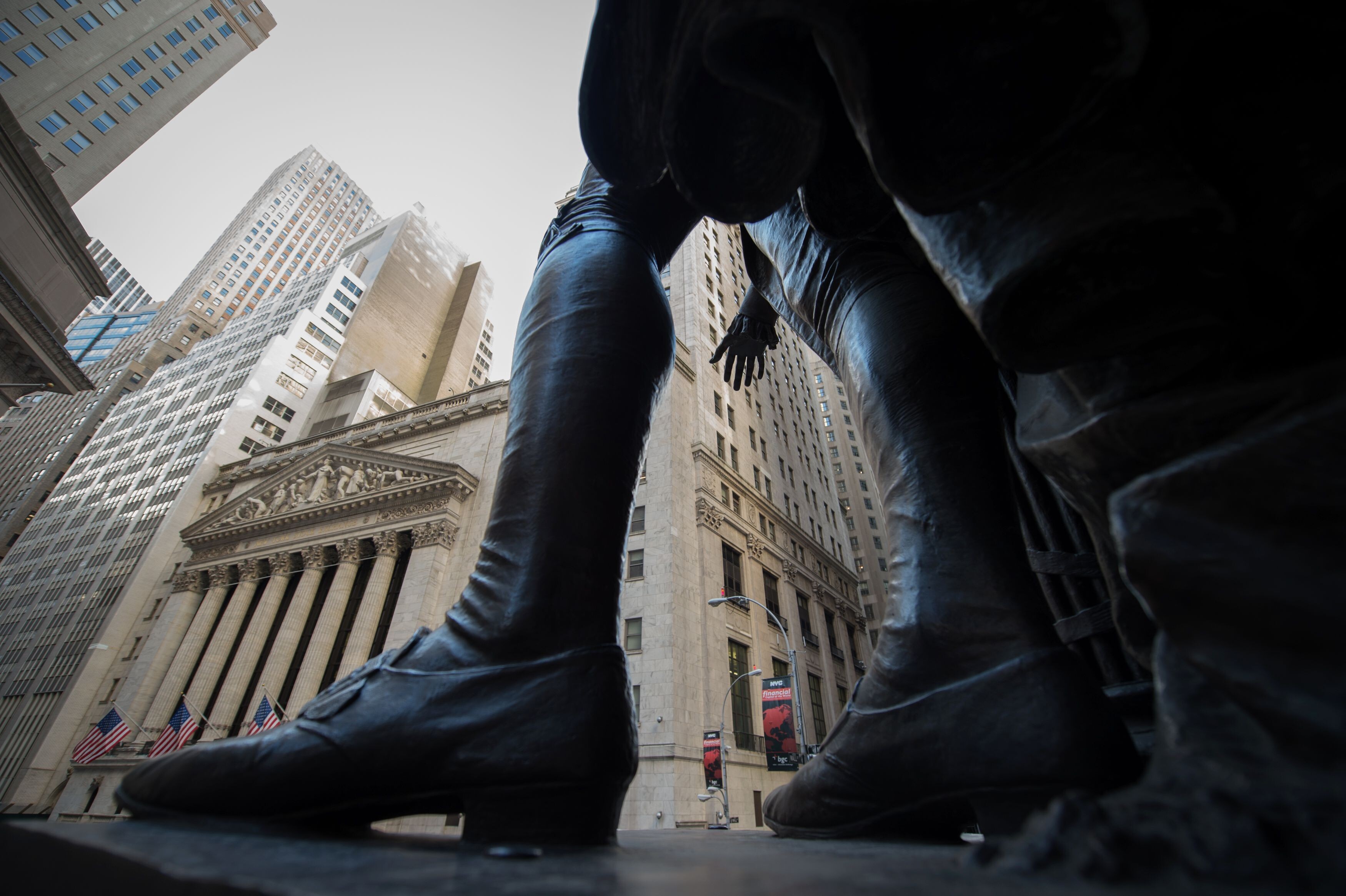 A statue of George Washington overlooks the New York Stock Exchange. In the worst-case scenario, should inflation surge and central banks stop mopping up bonds, stock markets could unravel. Photo: AFP