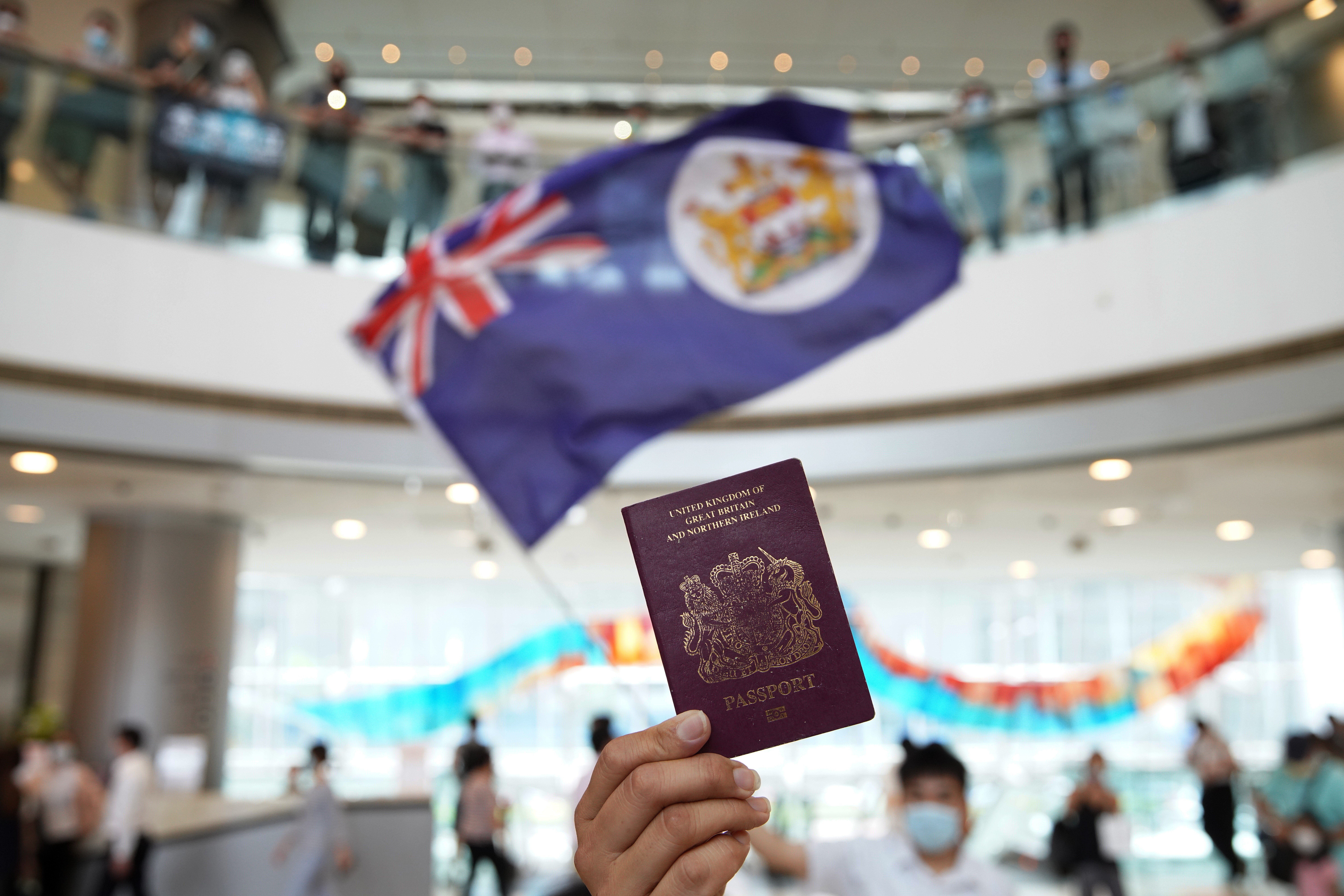 A protester holds up a BN(O) passport during an anti-government demonstration at IFC Mall on May 29, 2020. The British government has offered BN(O) passport holders the chance to settle in Britain and apply for citizenship. Photo: Winson Wong