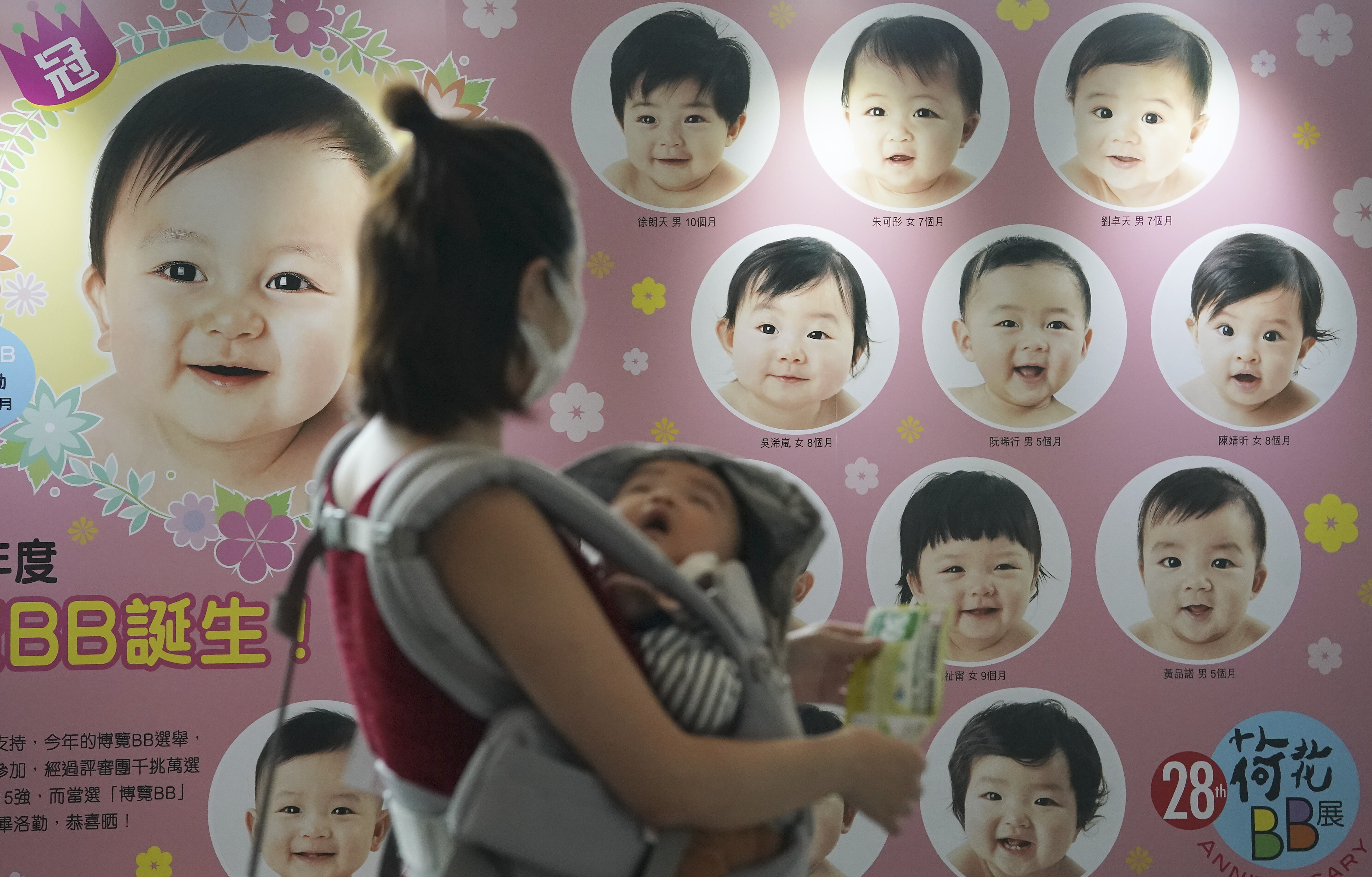 A woman walks past a signboard at a baby and children products expo at the Hong Kong Convention and Exhibition Centre in Wan Chai on October 22. Photo: Felix Wong