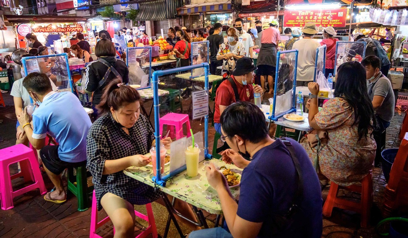 People dine separated by dividing screens at a street food corner in Bangkok’s Chinatown. Photo: AFP