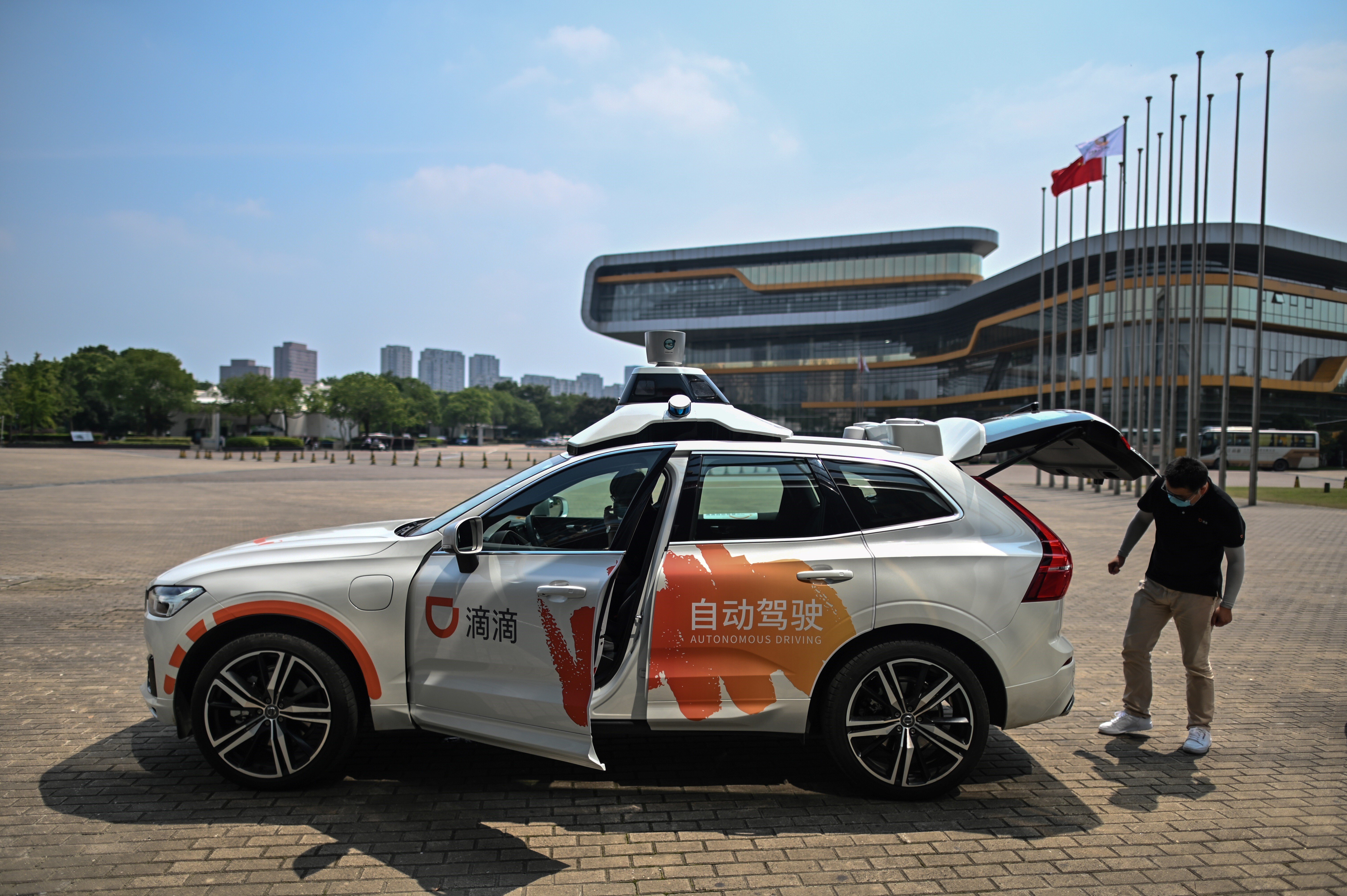 This photo taken on July 22, 2020 shows a driver (L) in a Didi Chuxing autonomous taxi preparing for a pilot test drive on the streets in Shanghai. Photo: AFP