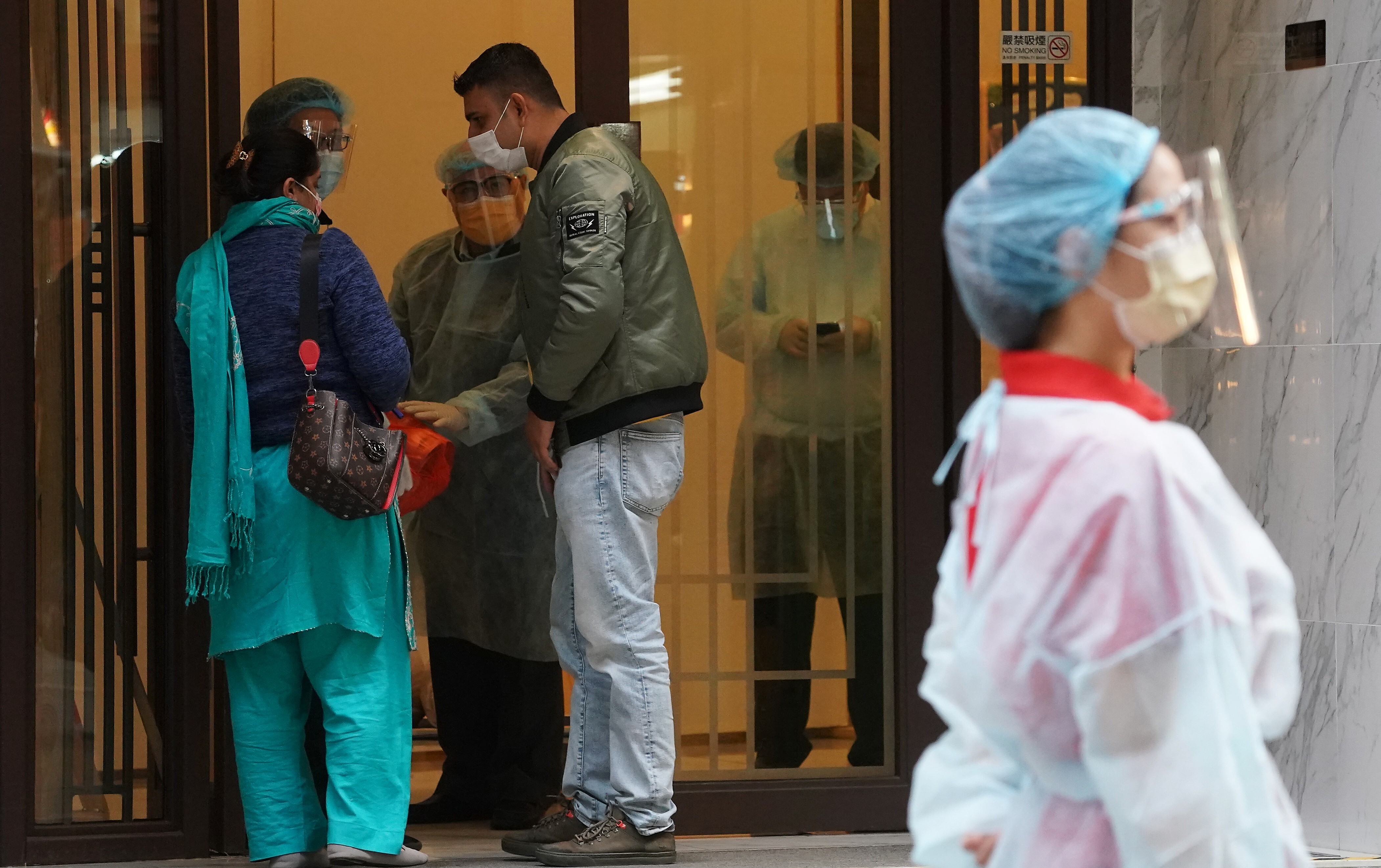 A staff member in protective gear waits for arriving guests at the Ramada Hong Kong Grand in North Point, a designated quarantine hotel, on December 21. The Hong Kong government has since tightened its quarantine requirements for arrivals. Photo: Felix Wong