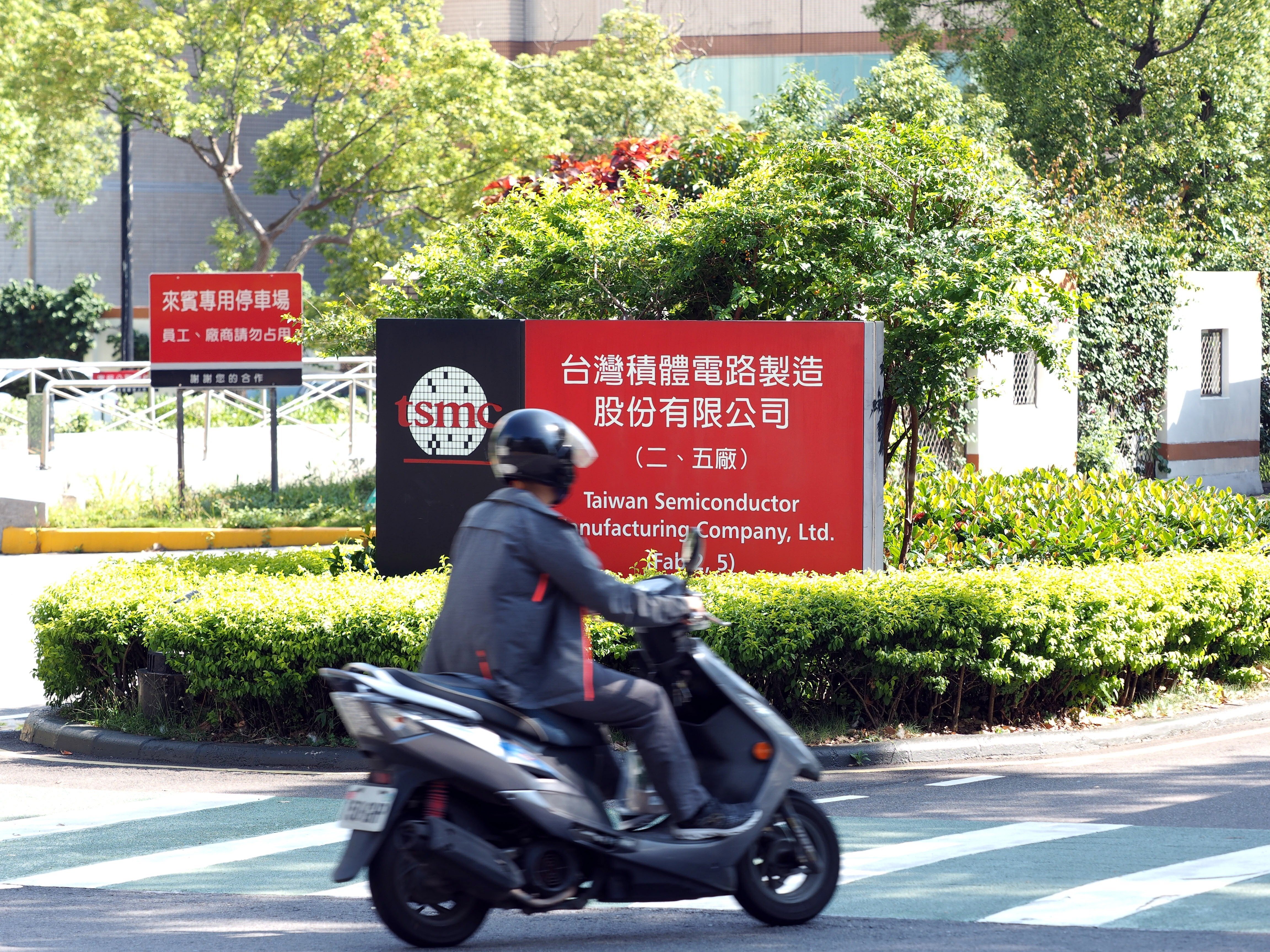 A motor cyclist rides past the logo of TSMC in Hsinchu, Taiwan, 15 May 2020. Photo: EPA-EFE