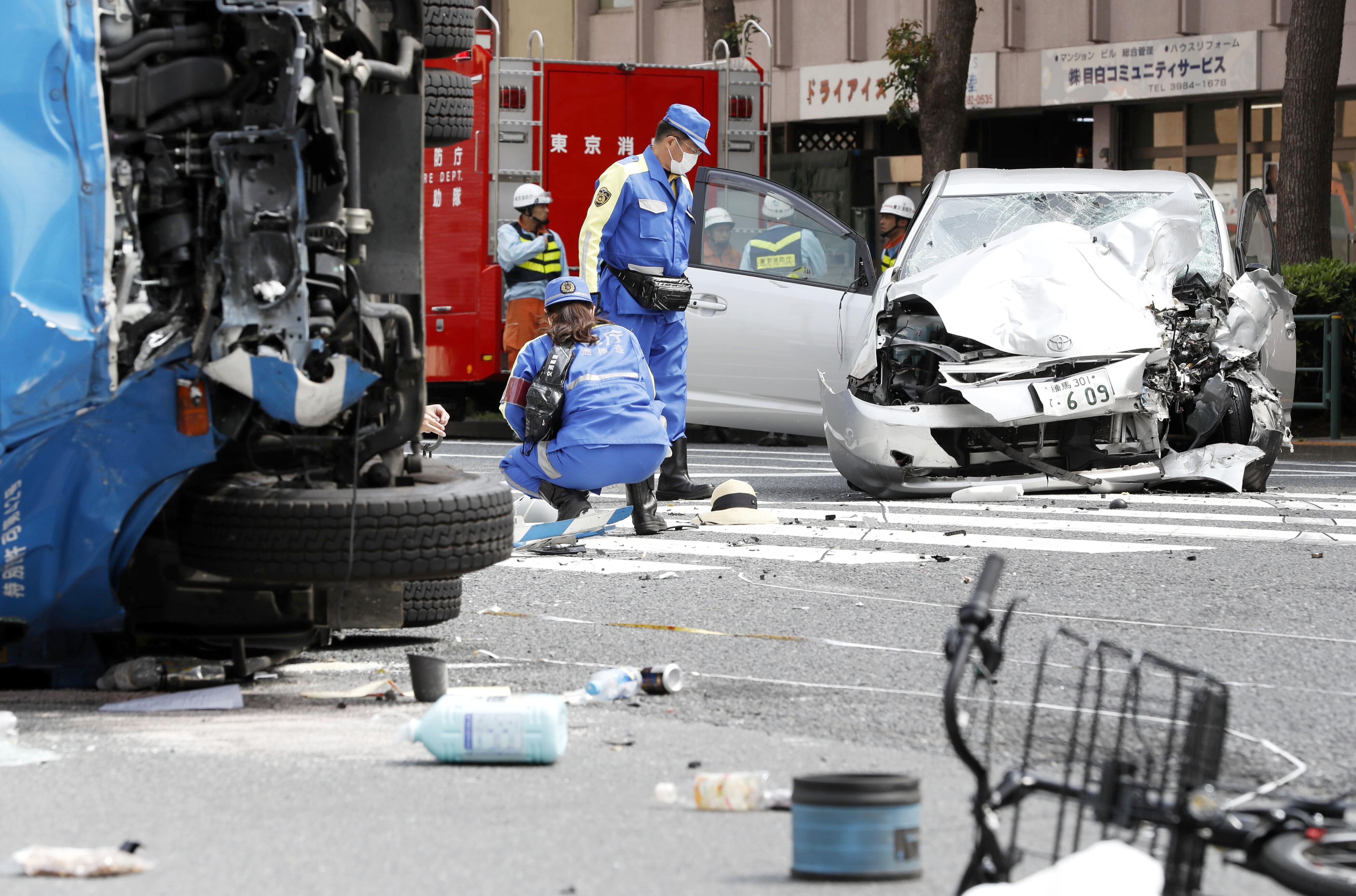 Police officers inspect the scene of a car accident in 2019 in which an elderly driver smashed into pedestrians at a Tokyo intersection, killing a woman and a girl on a bicycle and overturning a garbage truck. Photo: Kyodo