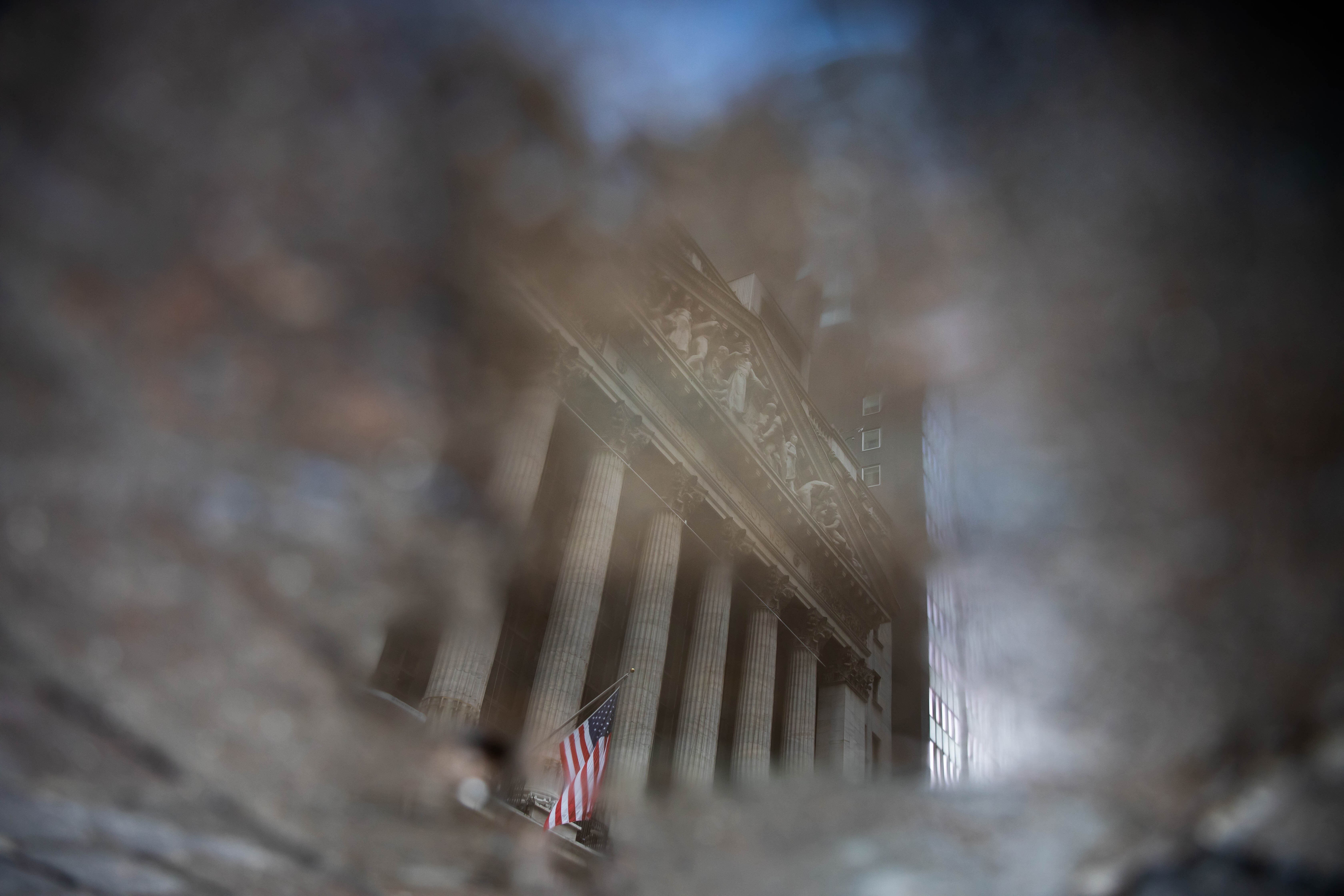 The New York Stock Exchange is reflected in a puddle on January 4. 2020 was a historic year marking a rapid plunge into bear market territory and a swift recovery into the bull zone. Photo: Bloomberg