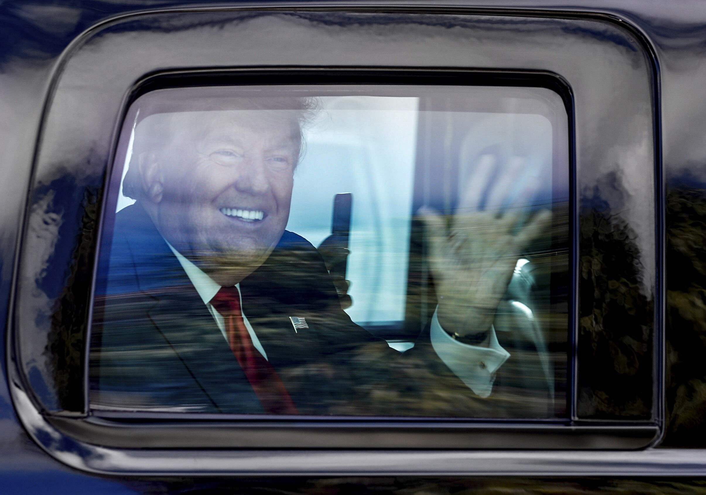 Former president Donald Trump waves to supporters as his motorcade drives through West Palm Beach, Florida. File photo: AP