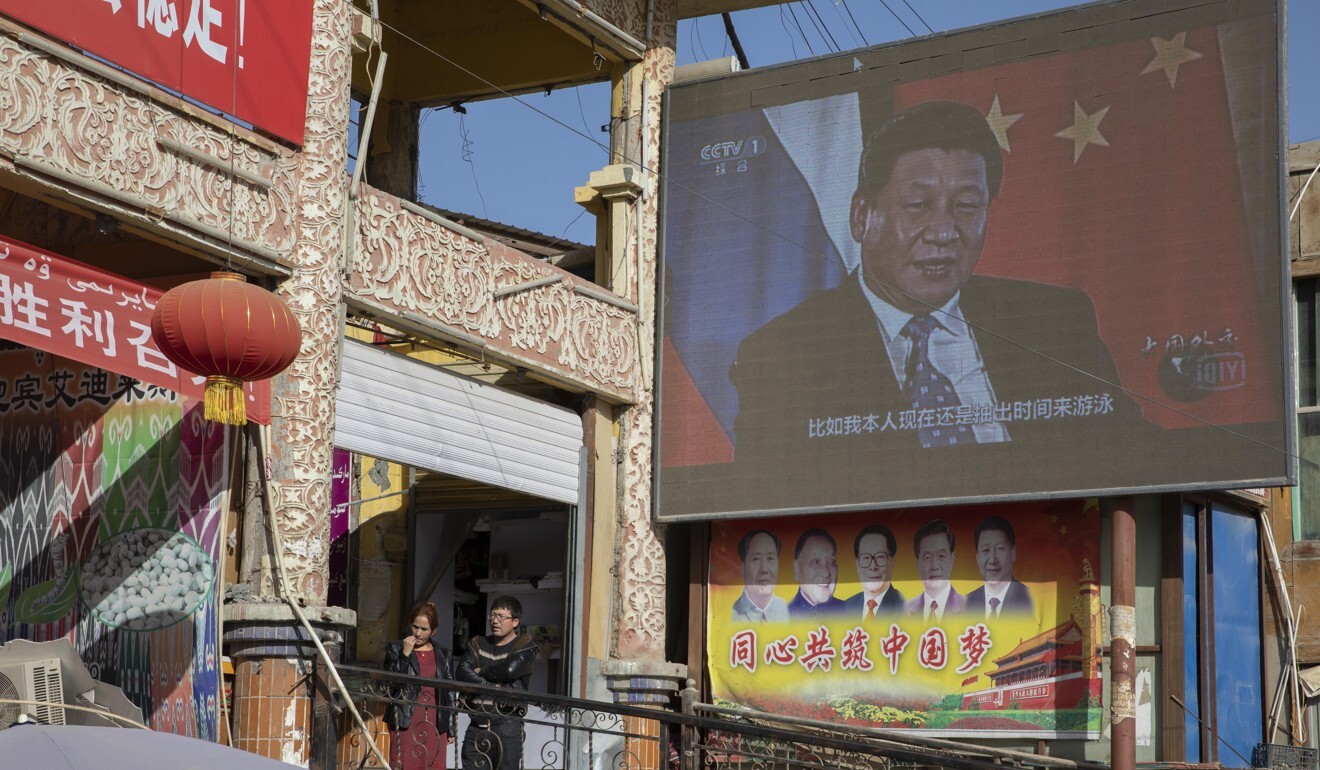 Chinese President Xi Jinping is seen on a screen near a bazaar in Hotan in western China's Xinjiang region in 2017. Photo: AP