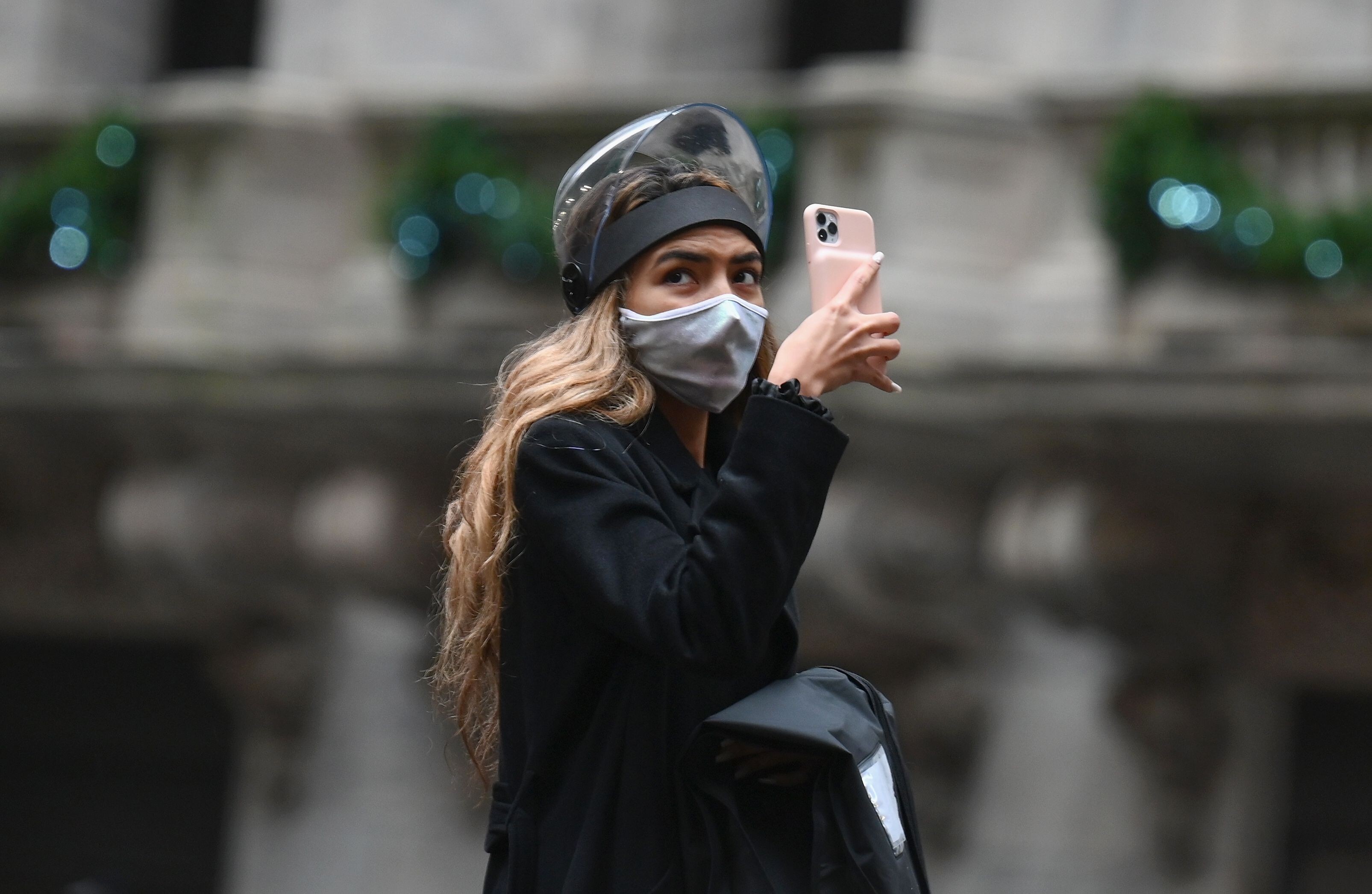 A woman takes a picture outside the New York Stock Exchange on November 30. Photo: AFP