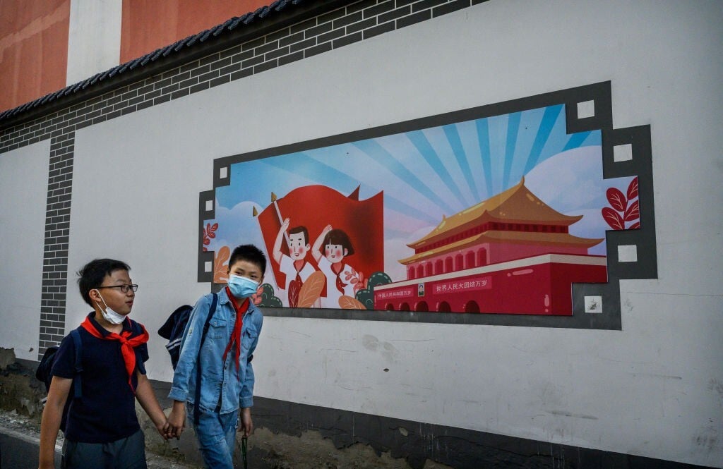 Chinese boys walk home together hand in hand from a local junior school in Beijing, China. Photo: Getty Images