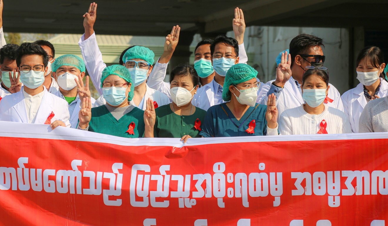 Medical staff wear red ribbon tags and raise the three-finger salutes in protest against the military coup in Mandalay on Wednesday. Photo: SOPA Images via ZUMA Wire/DPA