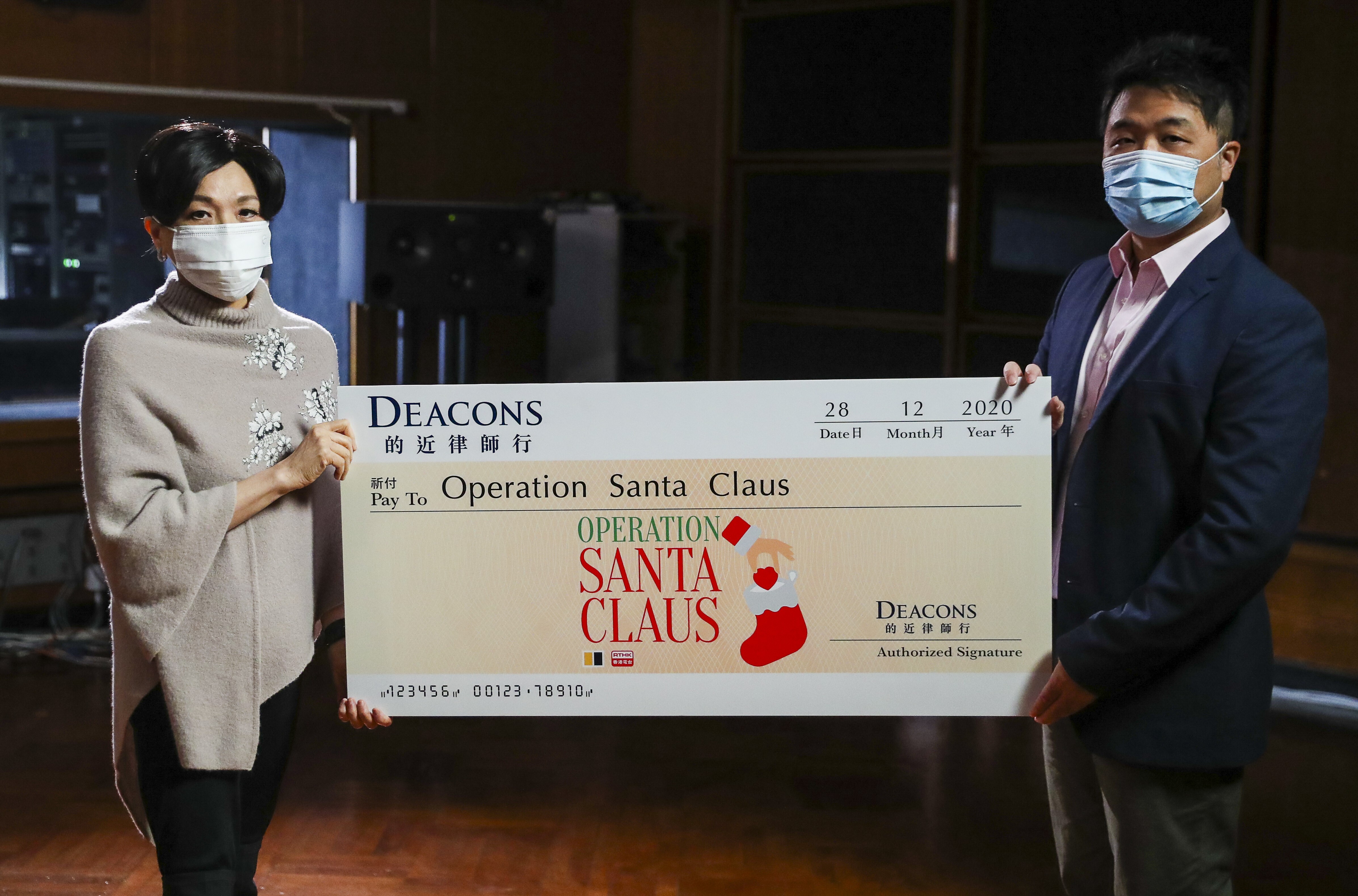 SCMP Charities Ltd project director Lawrence Wong (right) receives a cheque from DEACONS official Lilian Chiang in Kowloon Tong. Photo: Edmond So