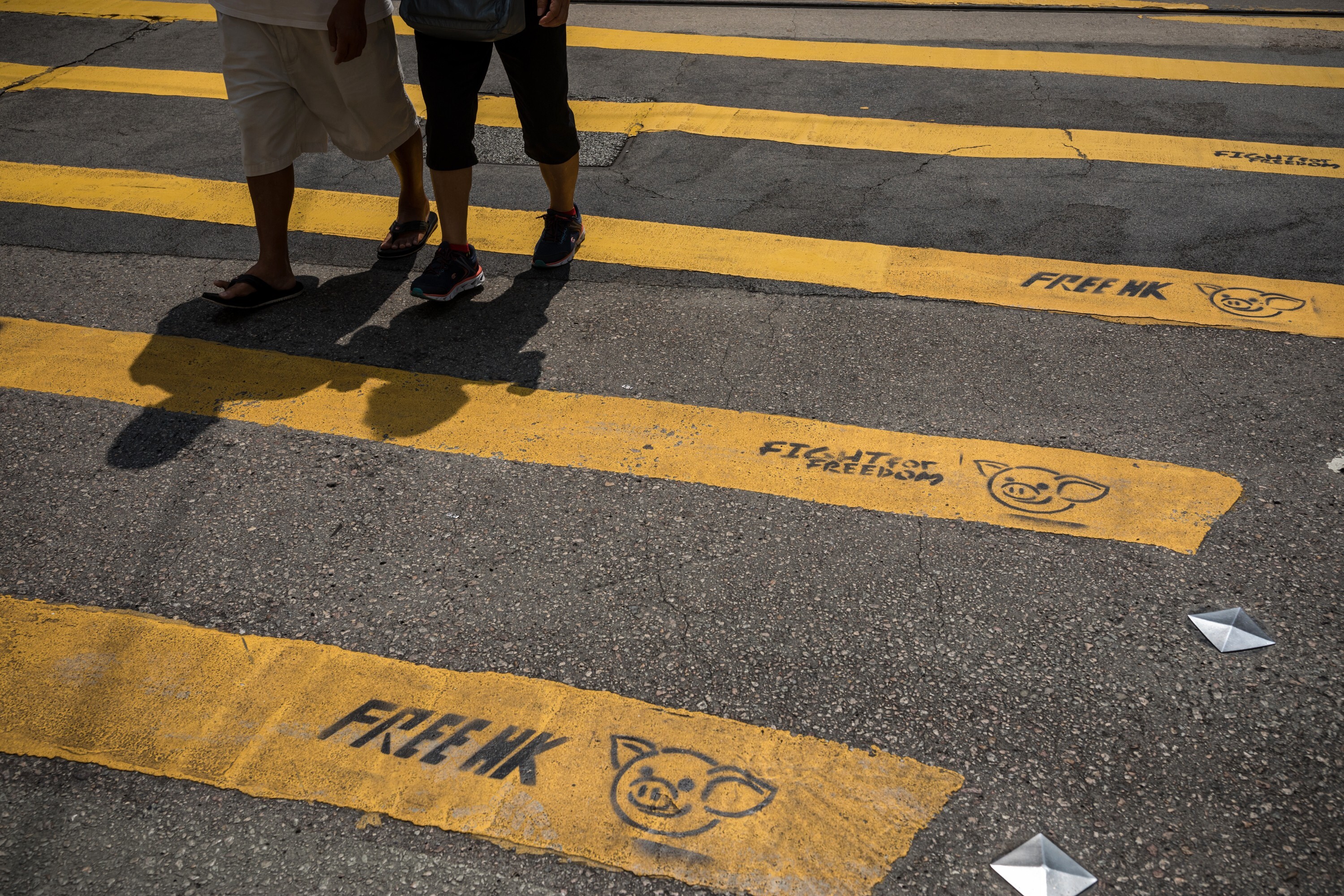 Pedestrians walk past graffiti on a pedestrian crossing reading “Free HK” and “Fight For Freedom” in Causeway Bay, Hong Kong, on October 2, 2019. Photo: Bloomberg