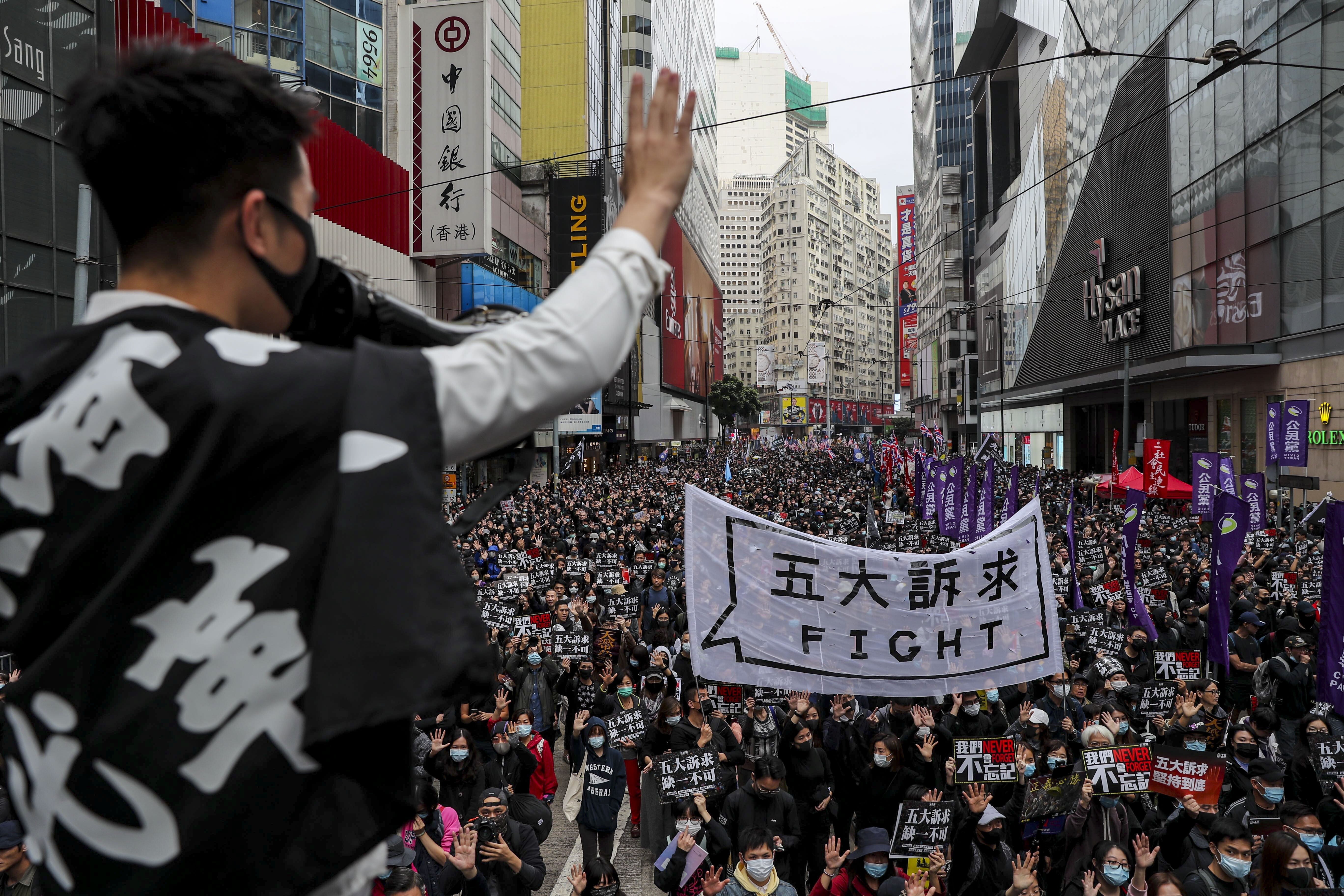 A protester holds up five fingers symbolising the movement’s five demands, including universal suffrage, during the annual New Year’s Day pro-democracy march, in Causeway Bay on January 1, 2020. Photo: Sam Tsang
