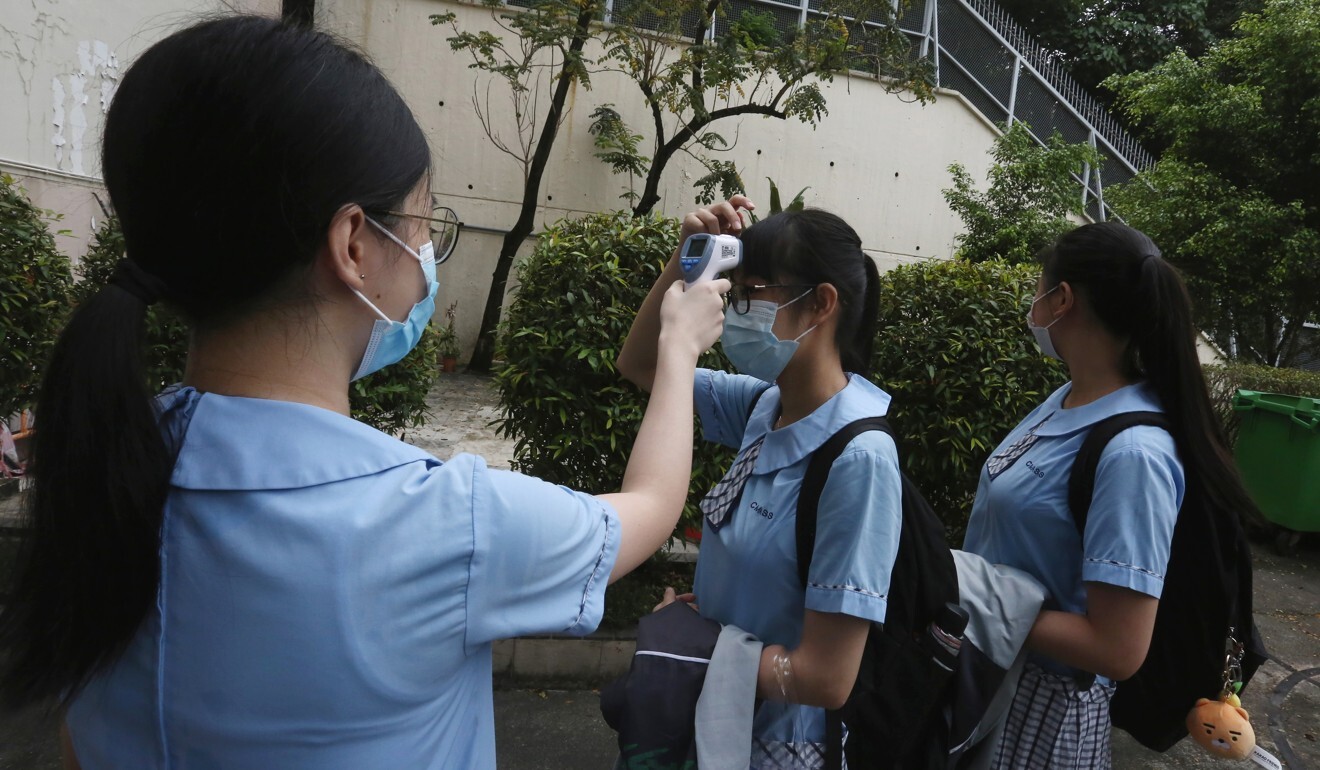 Secondary school students have their temperatures checked before entering campus. Photo: Jonathan Wong