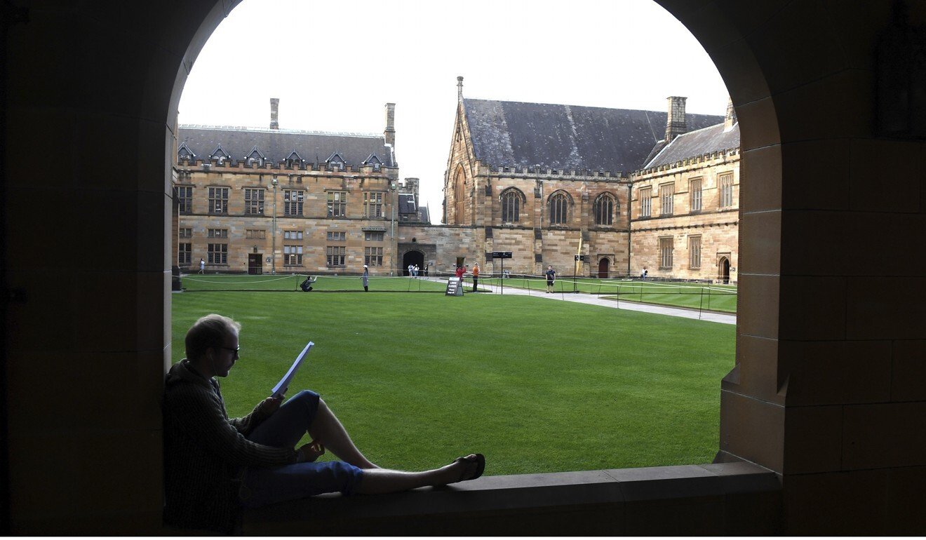 A student reads while sitting on a ledge at the Quadrangle of the University of Sydney, Australia. Photo: AP